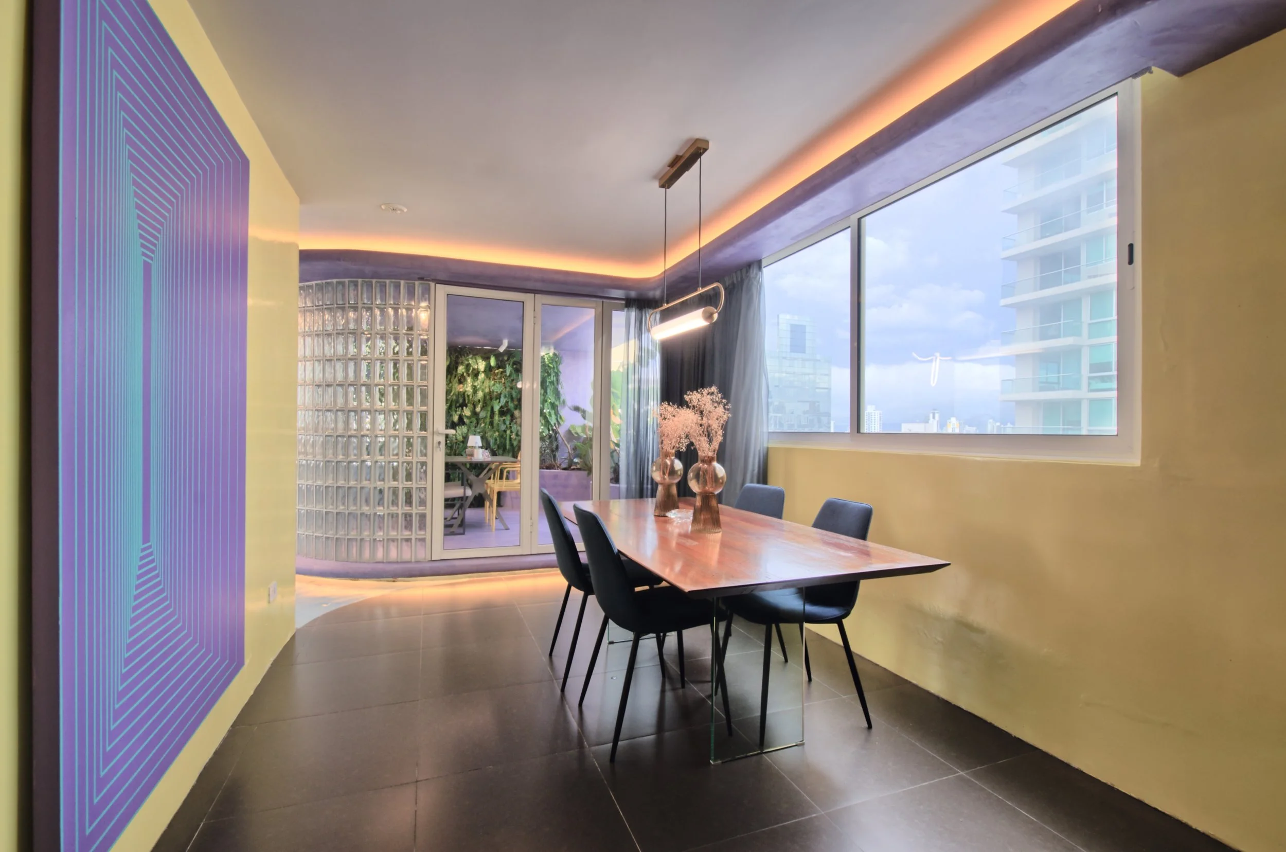 Modern dining room with wooden table, black chairs, large window, plants outside, and contemporary decor, including a pendant light and LED strip lighting.