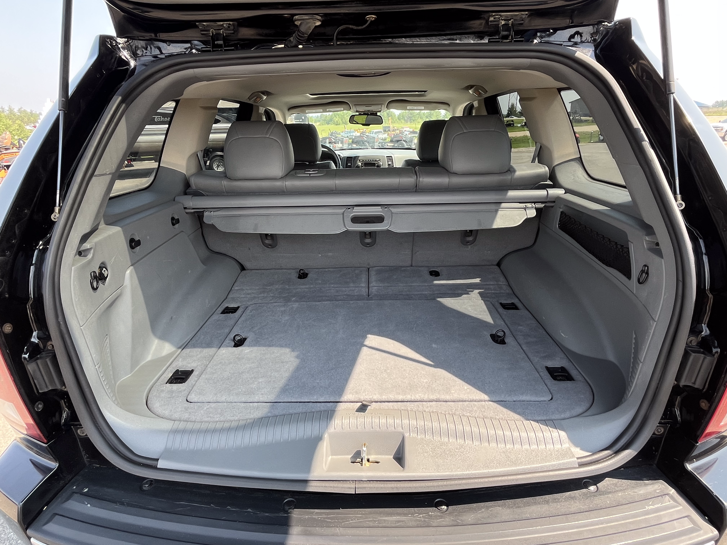 Empty black SUV rear cargo area with gray interior and rear seats upright