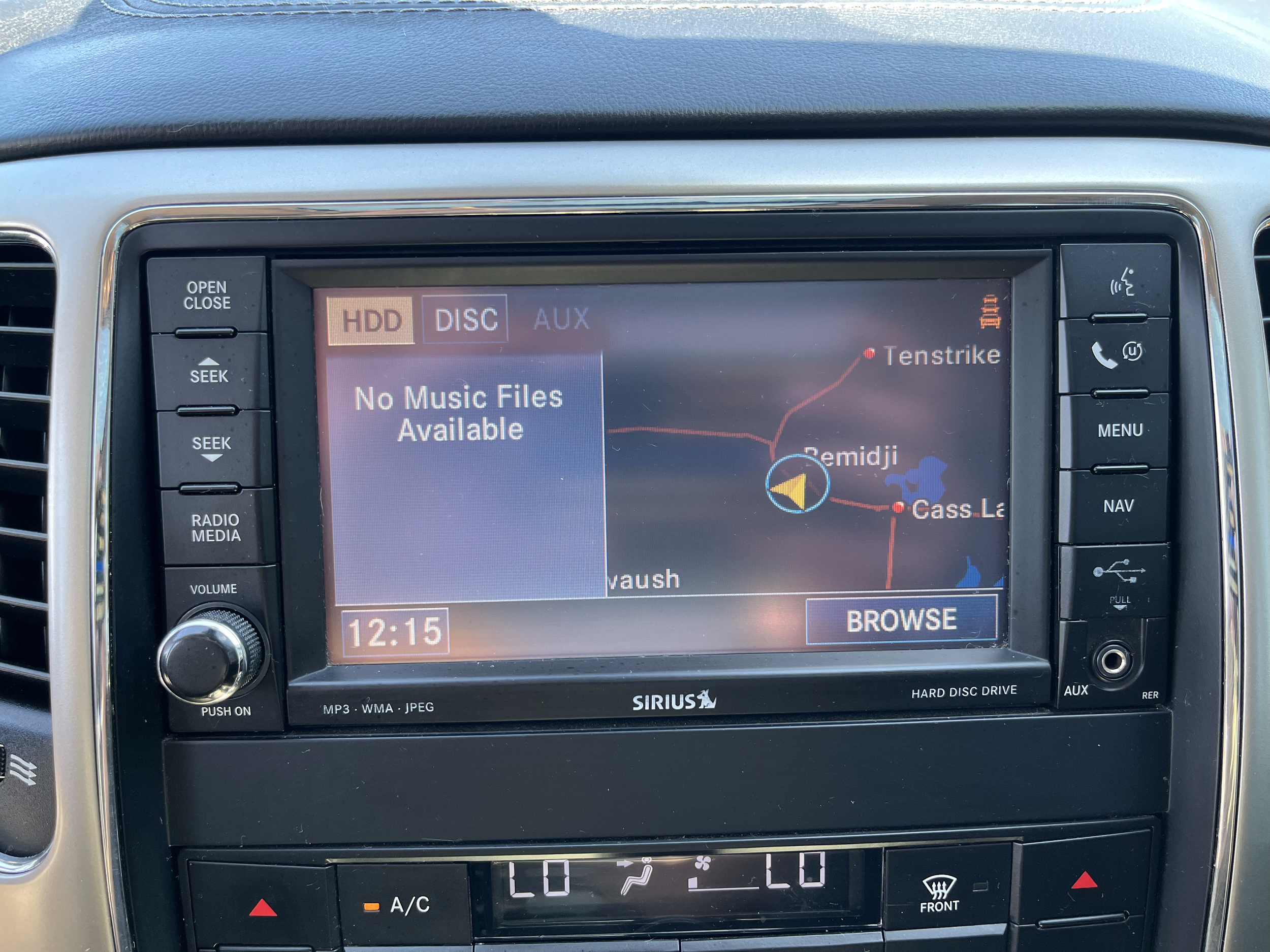 Car stereo display showing no music files available and a navigation map with red dots and lines.