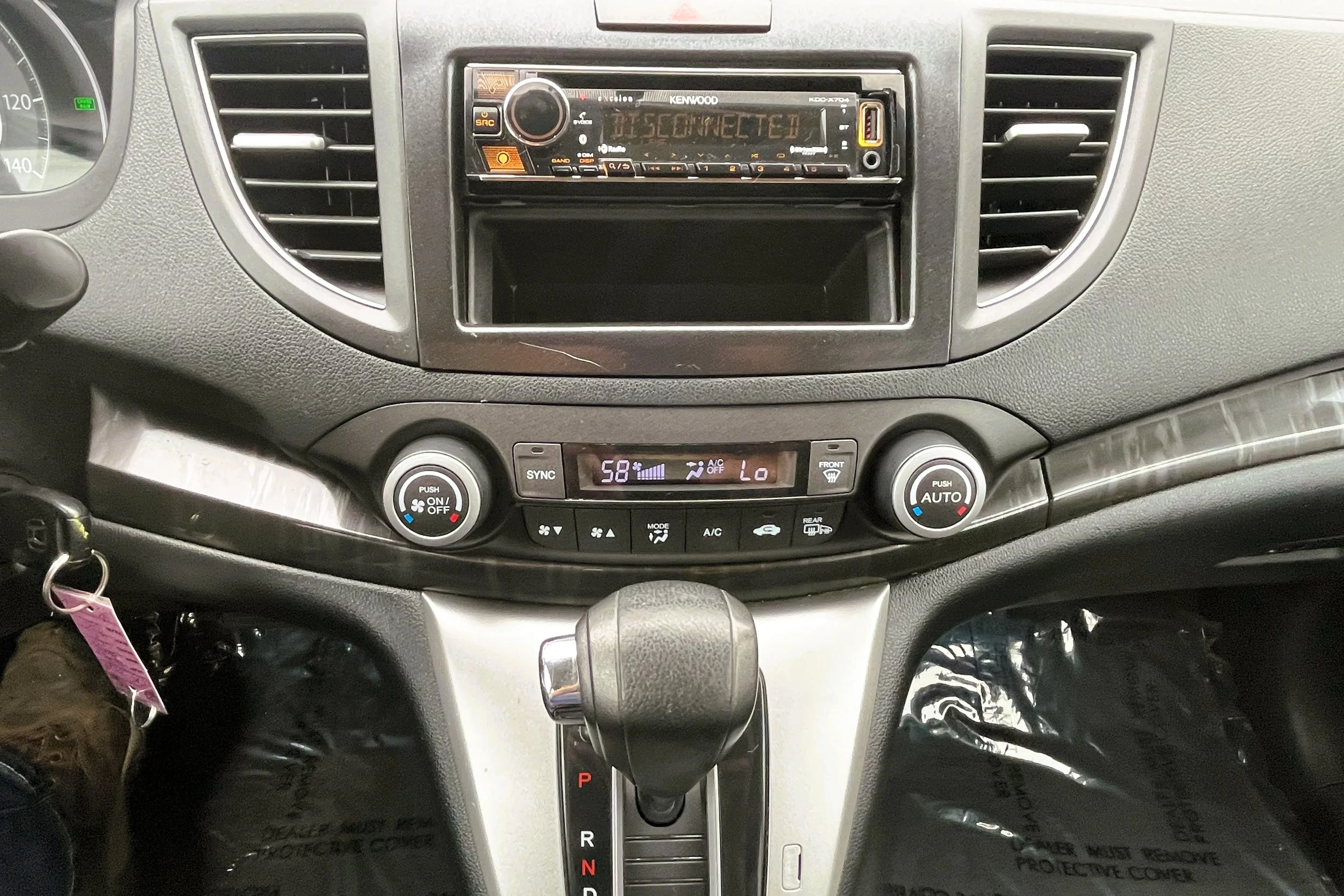 The interior dashboard of a vehicle showing a Kenwood stereo system with the display reading 'DISCONNECTED' and climate controls below, including temperature settings, fan speed, and defrost buttons.