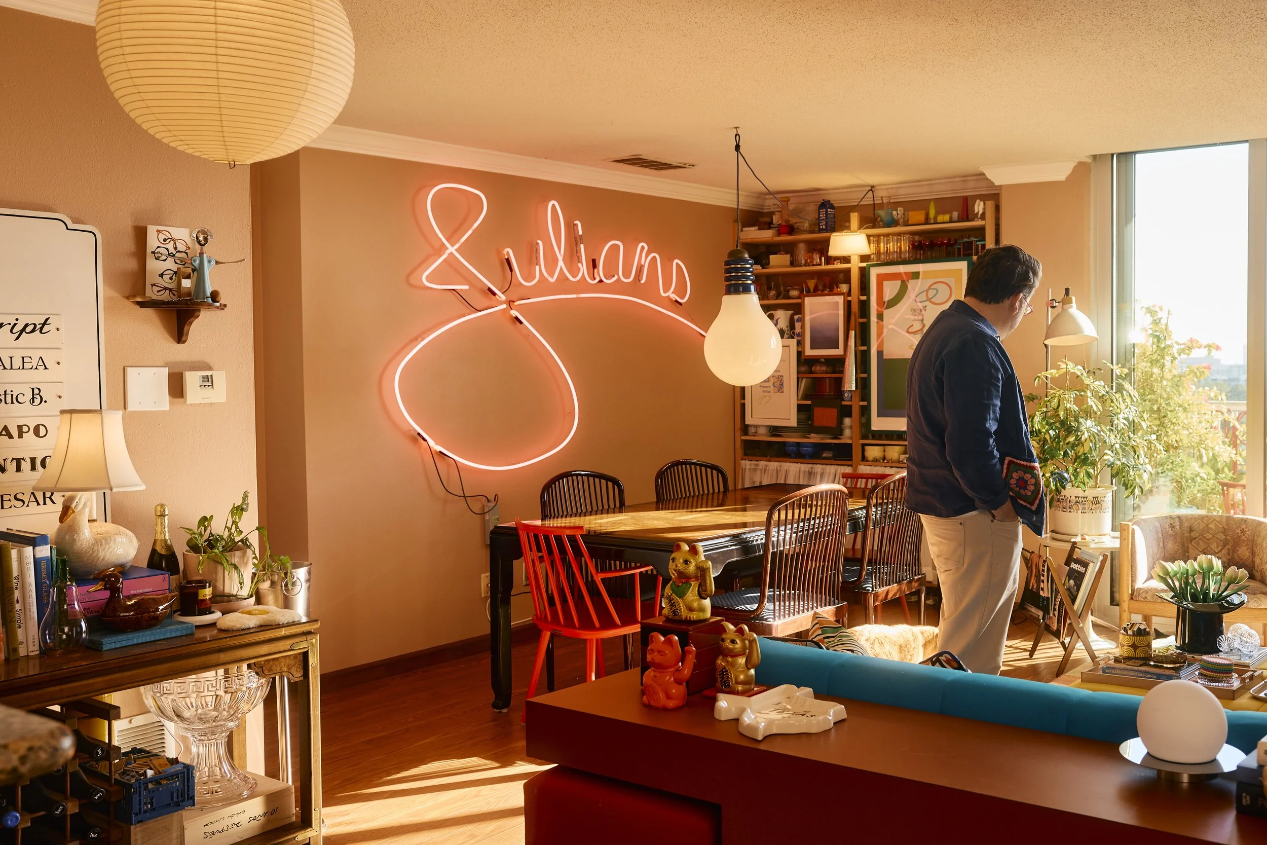 View of the pink neon "Julians" sign that hangs over Zach and Taylor's dining room table in their Houston, TX apartment. Image by Austin-based lifestyle photographer, Mackenzie Smith.