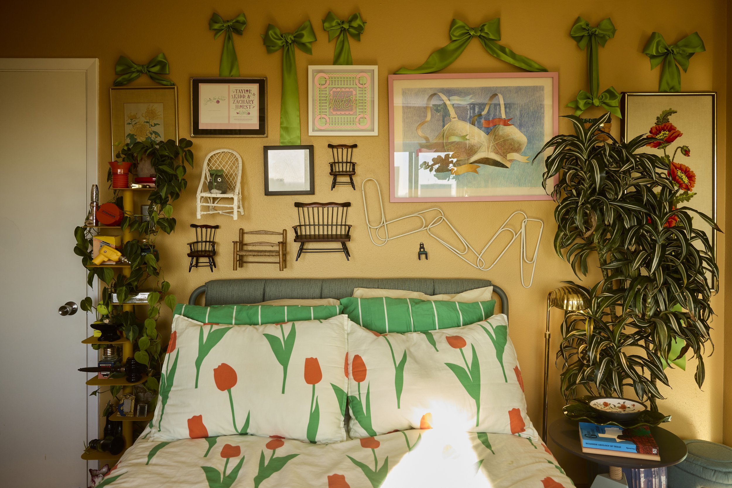 Green plants frame the bed while silk green bows encompass the room in Zach and Taylor's eclectic Houston, TX apartment. Image by Austin-based lifestyle photographer, Mackenzie Smith.