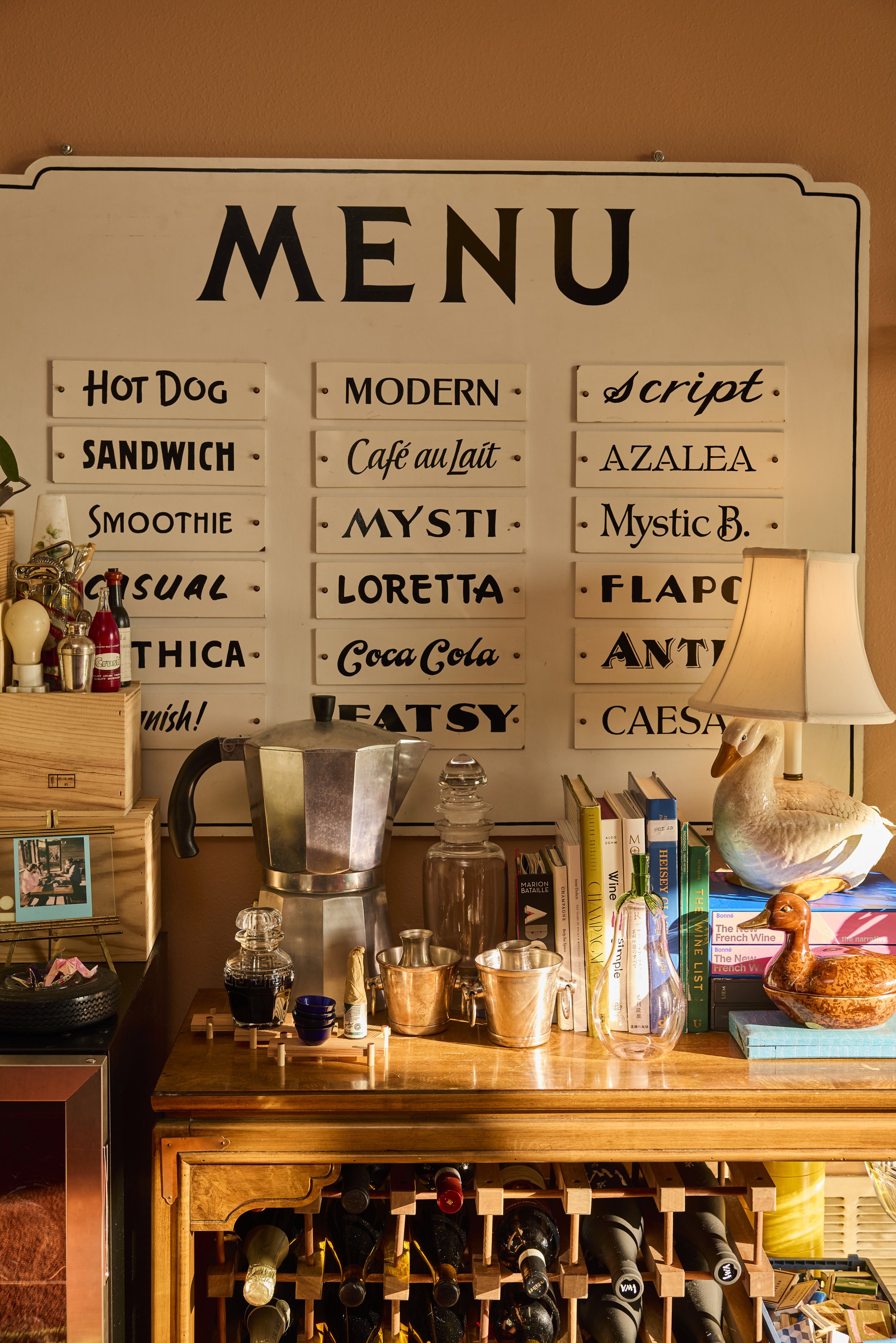 Menu sign originally from New Orleans now sits on top of the wine cabinet in Zach and Taylor's Houston, TX apartment. Image by Austin-based lifestyle photographer, Mackenzie Smith.