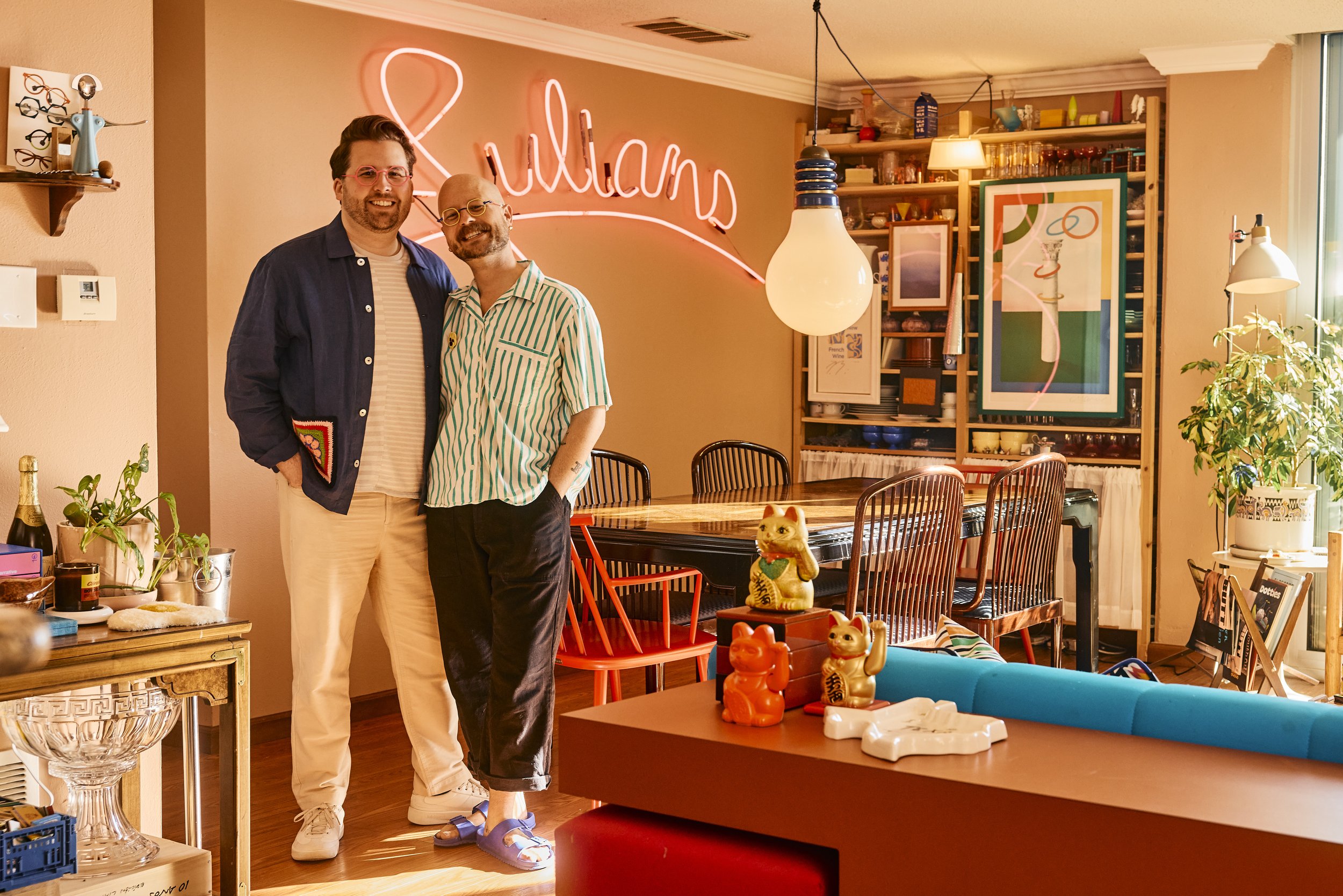 Zach and Taylor in their dining room in Houston, TX featuring a pink neon sign. Image by Austin-based lifestyle photographer, Mackenzie Smith.