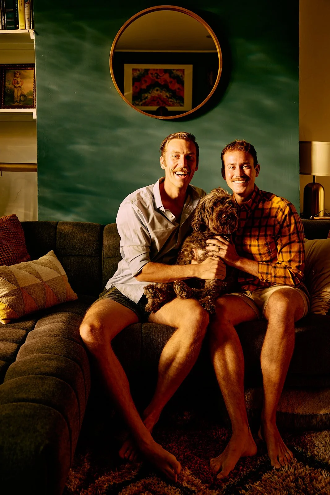 Alexander, Bobby, and their dog sitting on their couch in their Pittsburgh, PA townhouse. Image by Austin-based lifestyle photographer, Mackenzie Smith.