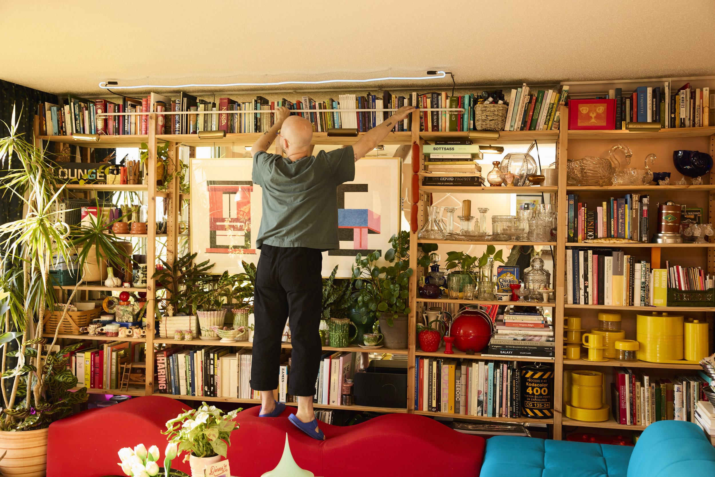 Zach showing how he gets books from the top shelf in his home library in Houston, TX. Image by Austin-based portrait and lifestyle photographer, Mackenzie Smith.