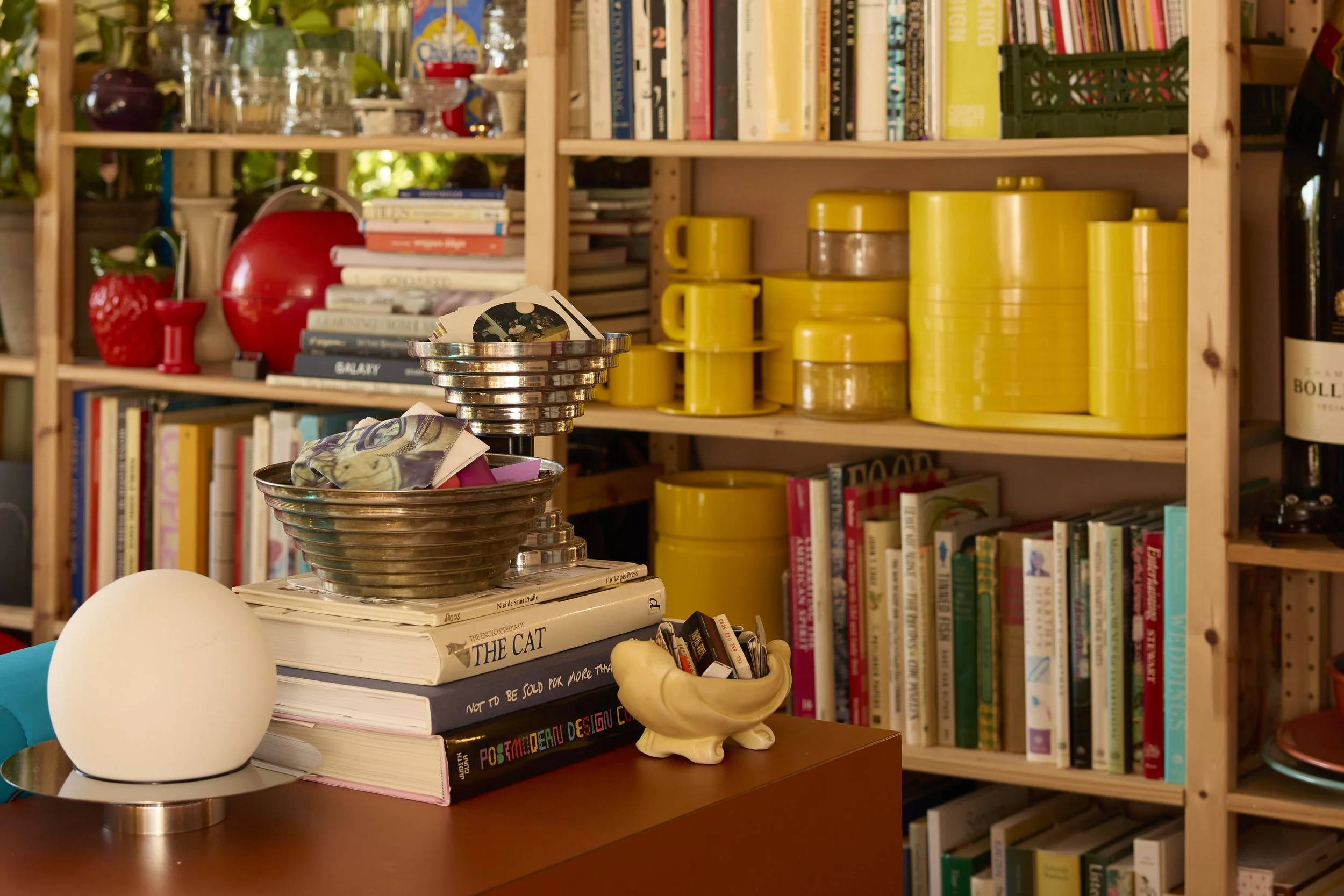 Eclectic mix of books, dishware, and colorful knick-knacks line the shelves in Zach and Taylor's Houston, TX apartment. Image by Austin-based lifestyle photographer, Mackenzie Smith.