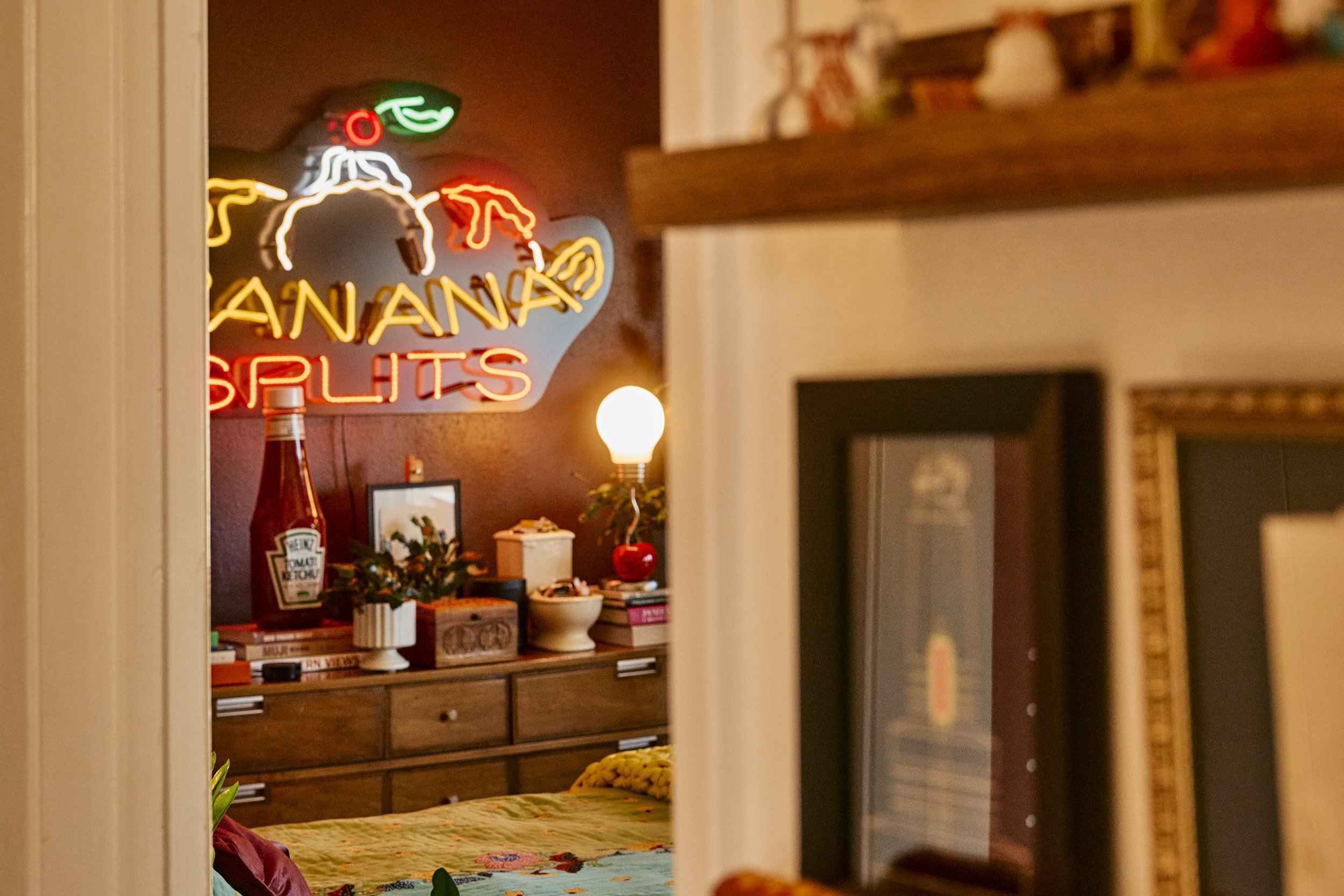 Banana Splits neon sign in a bedroom of Zach and Taylor's Houston, TX apartment. Image by Austin-based lifestyle photographer, Mackenzie Smith.
