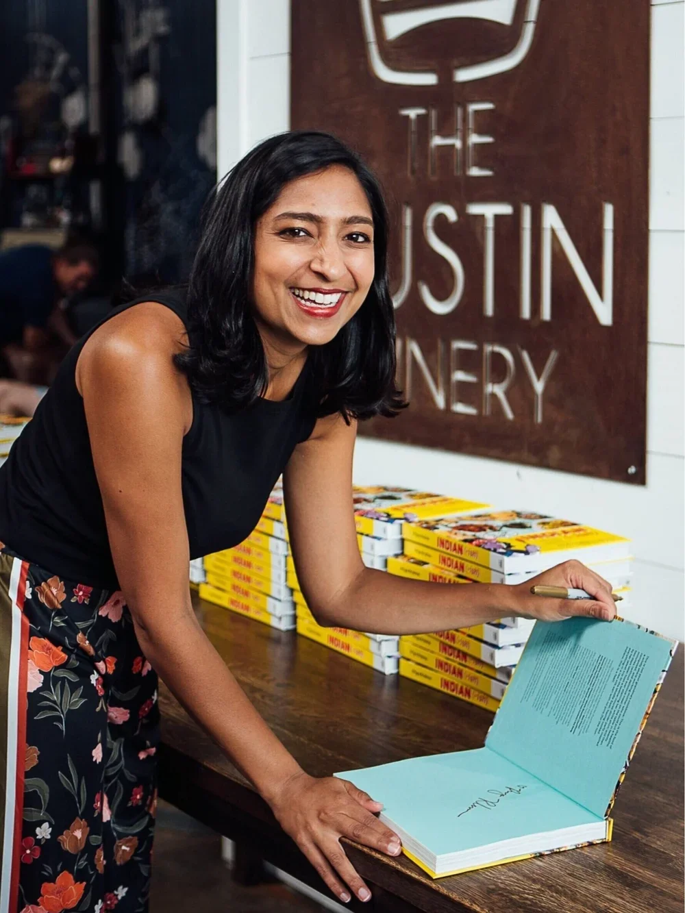 Priya Krishna signing her cookbook, Priya's Kitchen Adventures. Image by Austin-based food and portrait photographer, Mackenzie Smith.