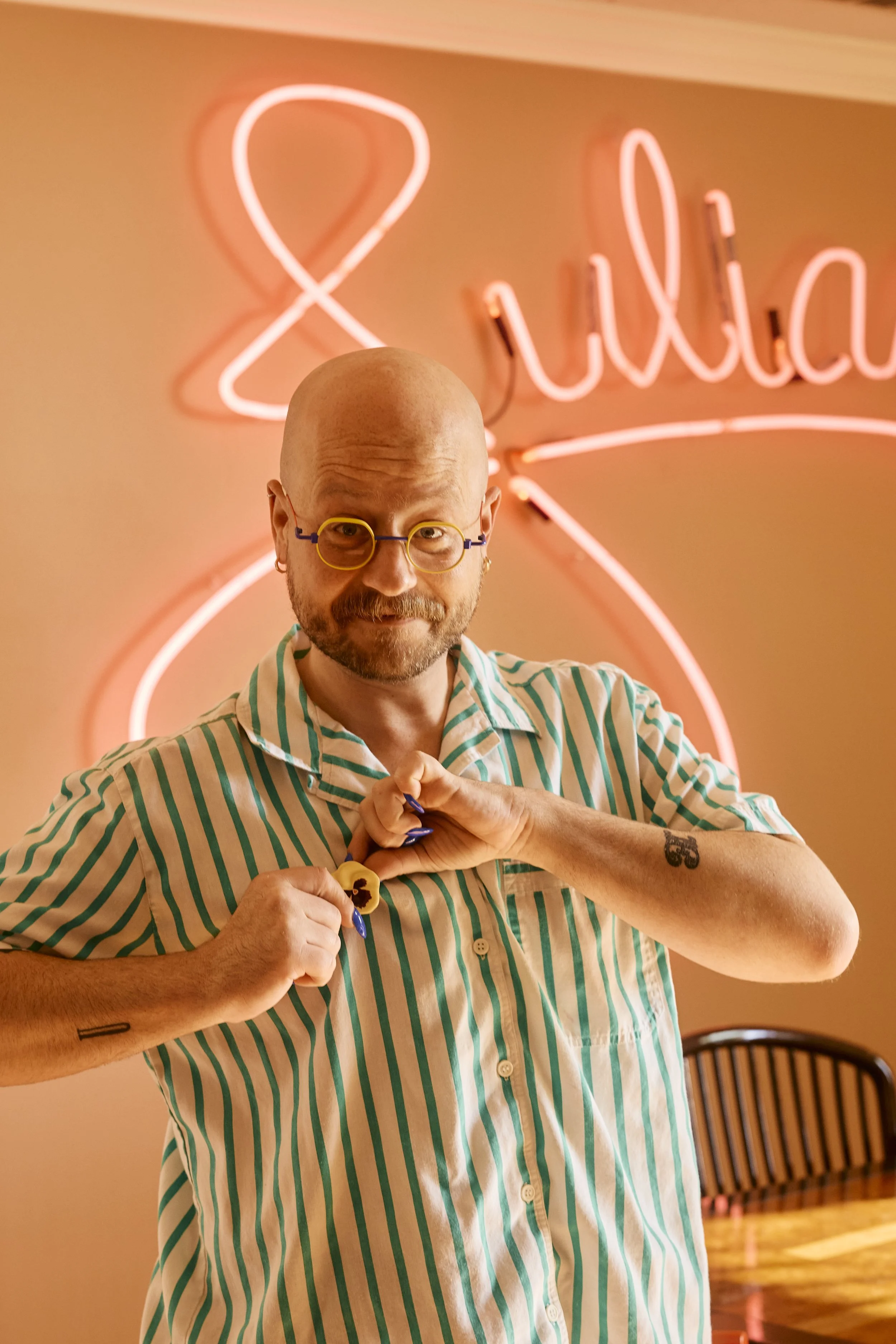 Zach in his dining room with pink neon sign, Houston, TX. Image by Austin-based portrait photographer, Mackenzie Smith.