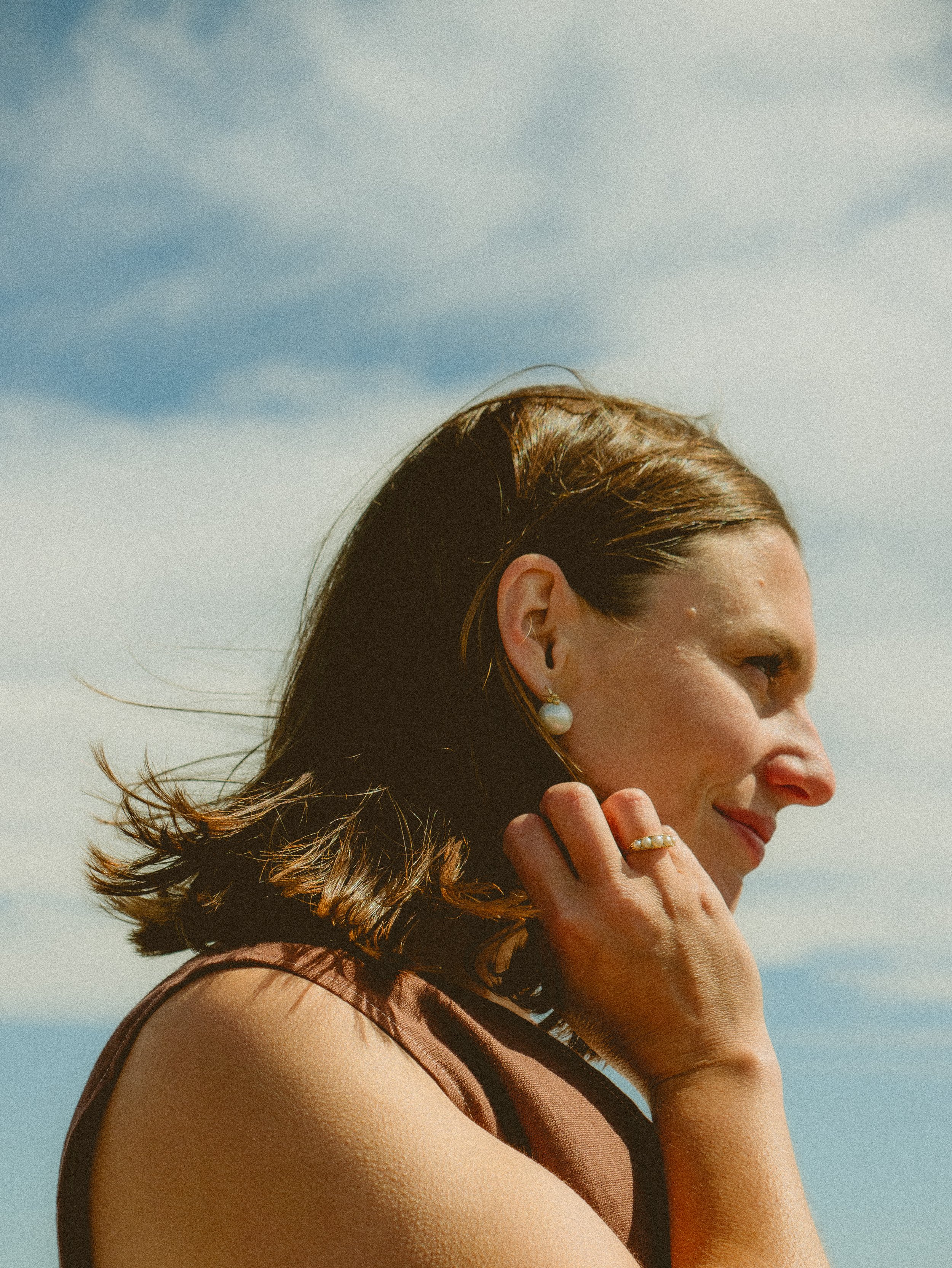 Lucy Randle, founder of Landed, standing outdoors with a cloudy sky in the background.