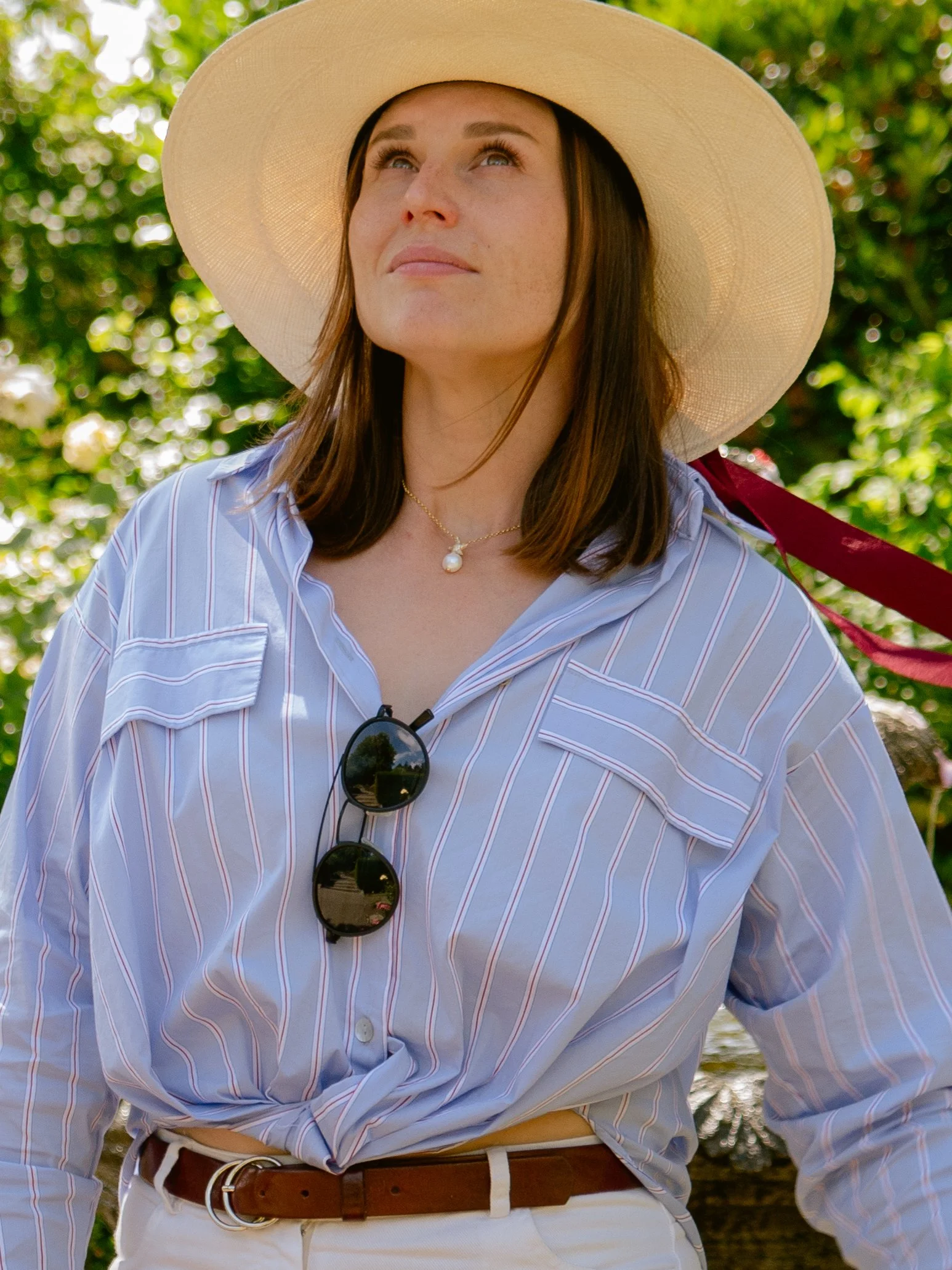 Woman wearing a wide-brimmed sun hat and striped shirt outdoors