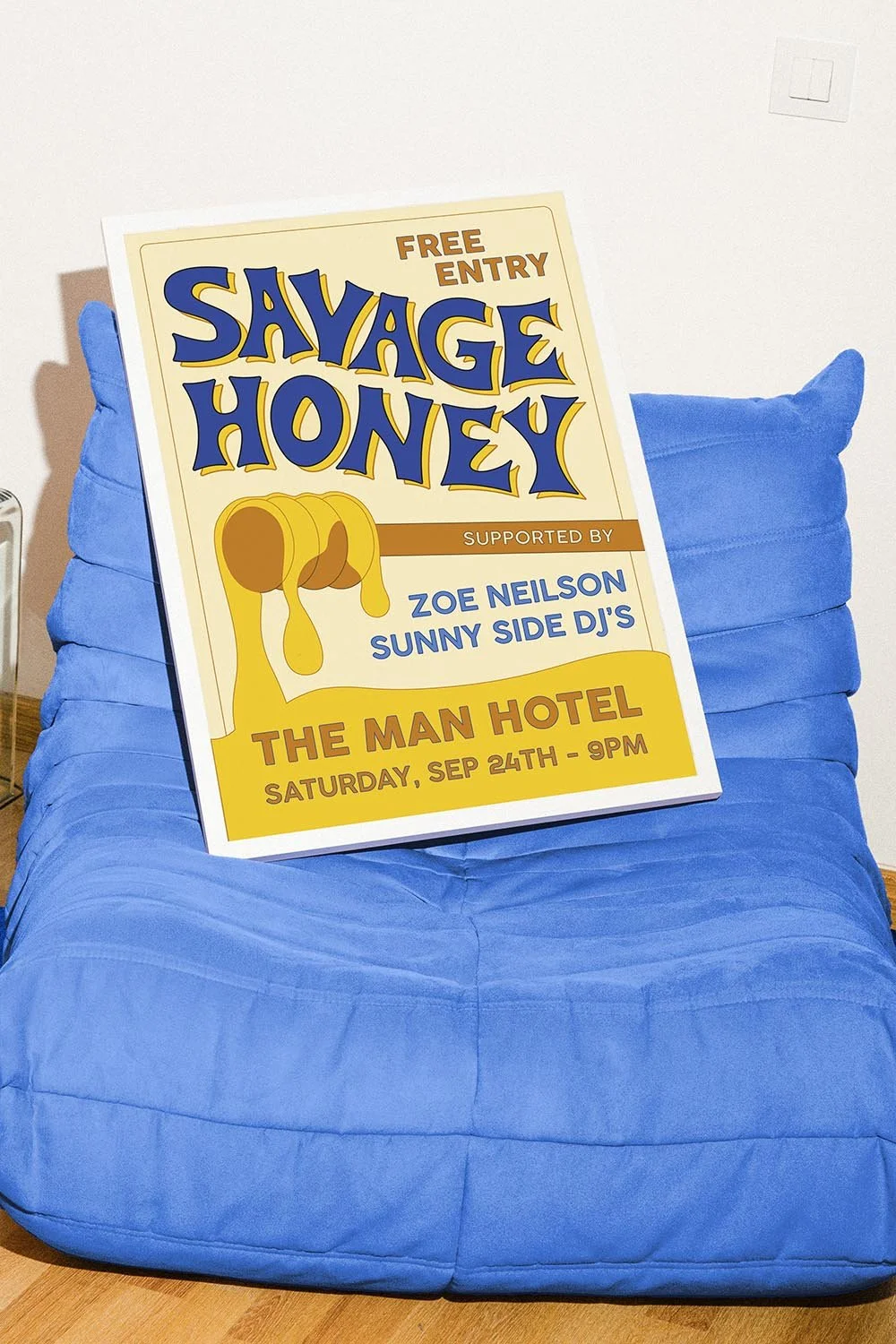 Yellow and blue framed poster for a band called Savage Honey leaned against a blue couch