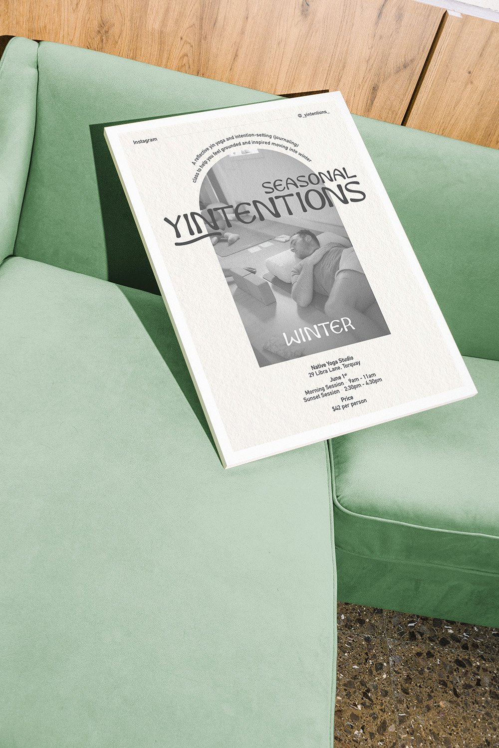 A black and white framed poster of a yoga event with a photo of a man stretching leaning against a green couch
