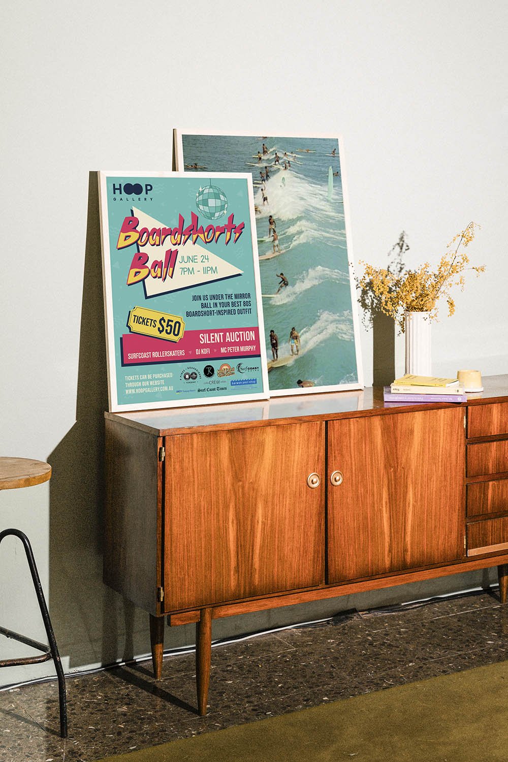 A framed, retro looking poster for Hoop Gallery's Boardshorts Ball sitting on top of a retro storage unit