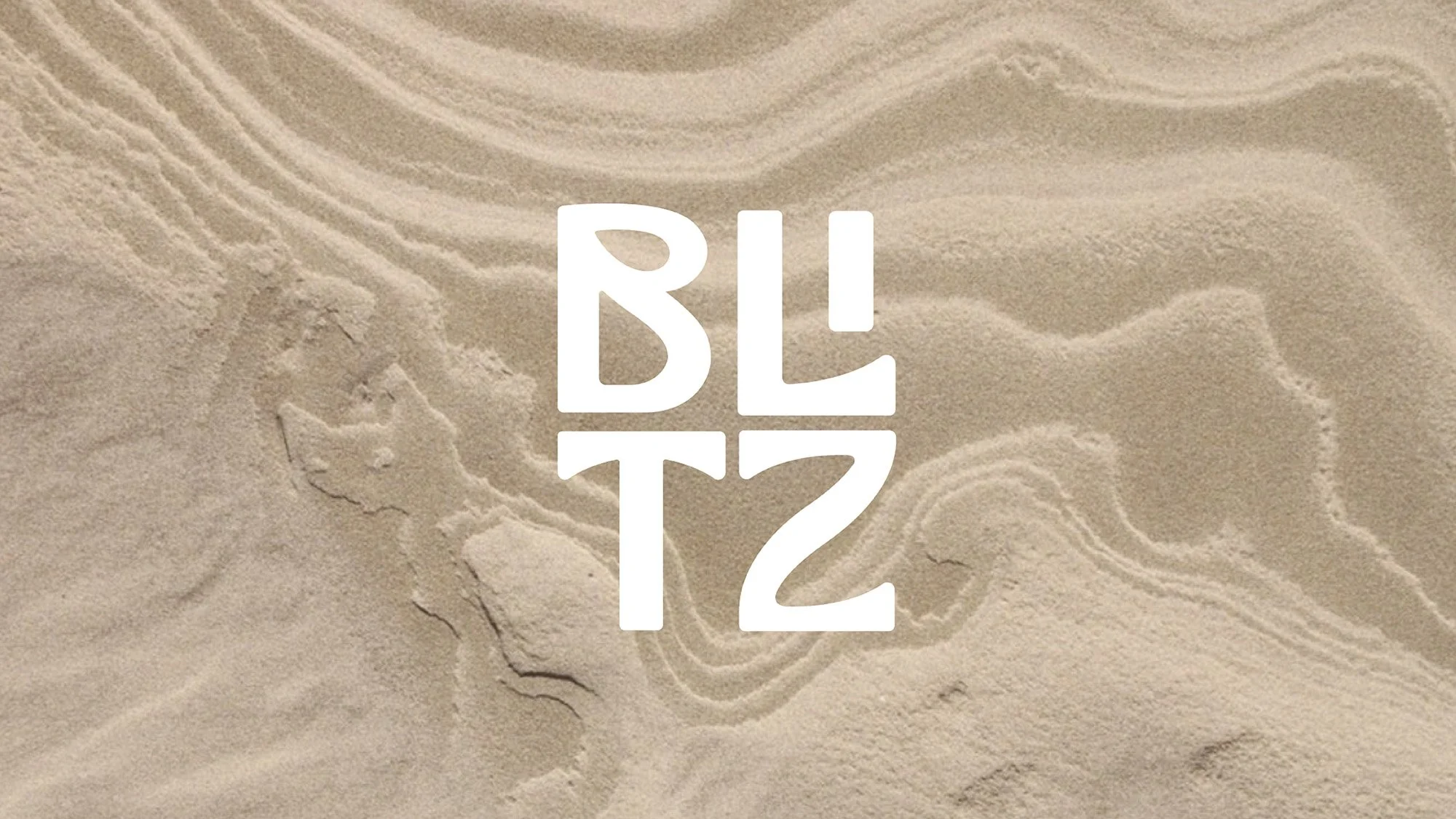 Close-up of sand with the words 'BLITZ' written in stylised white text.
