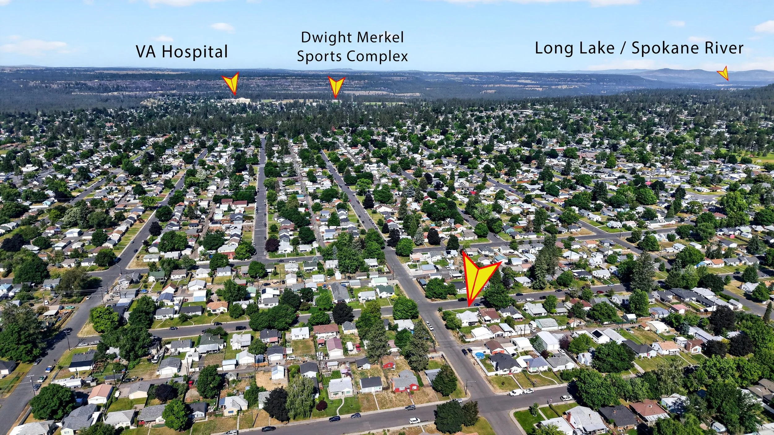 Aerial view of a suburban neighborhood with streets, houses, and trees. In the background are labels pointing out VA Hospital, Dwight Merkel Sports Complex, and Long Lake / Spokane River.