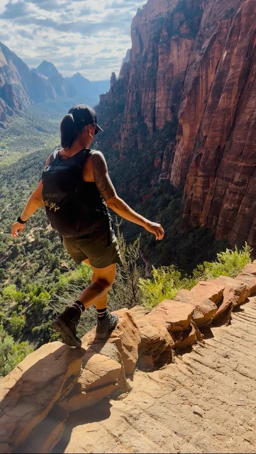 Cynthia hiking a narrow ridge trail in Zion
