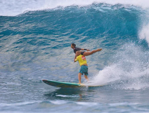 Stephanie and her partner tandem surfing down the face of a 20-foot wave at Mākaha