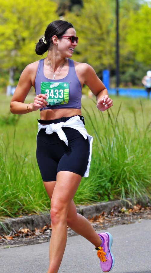 Tricia smiling mid-stride while running a marathon