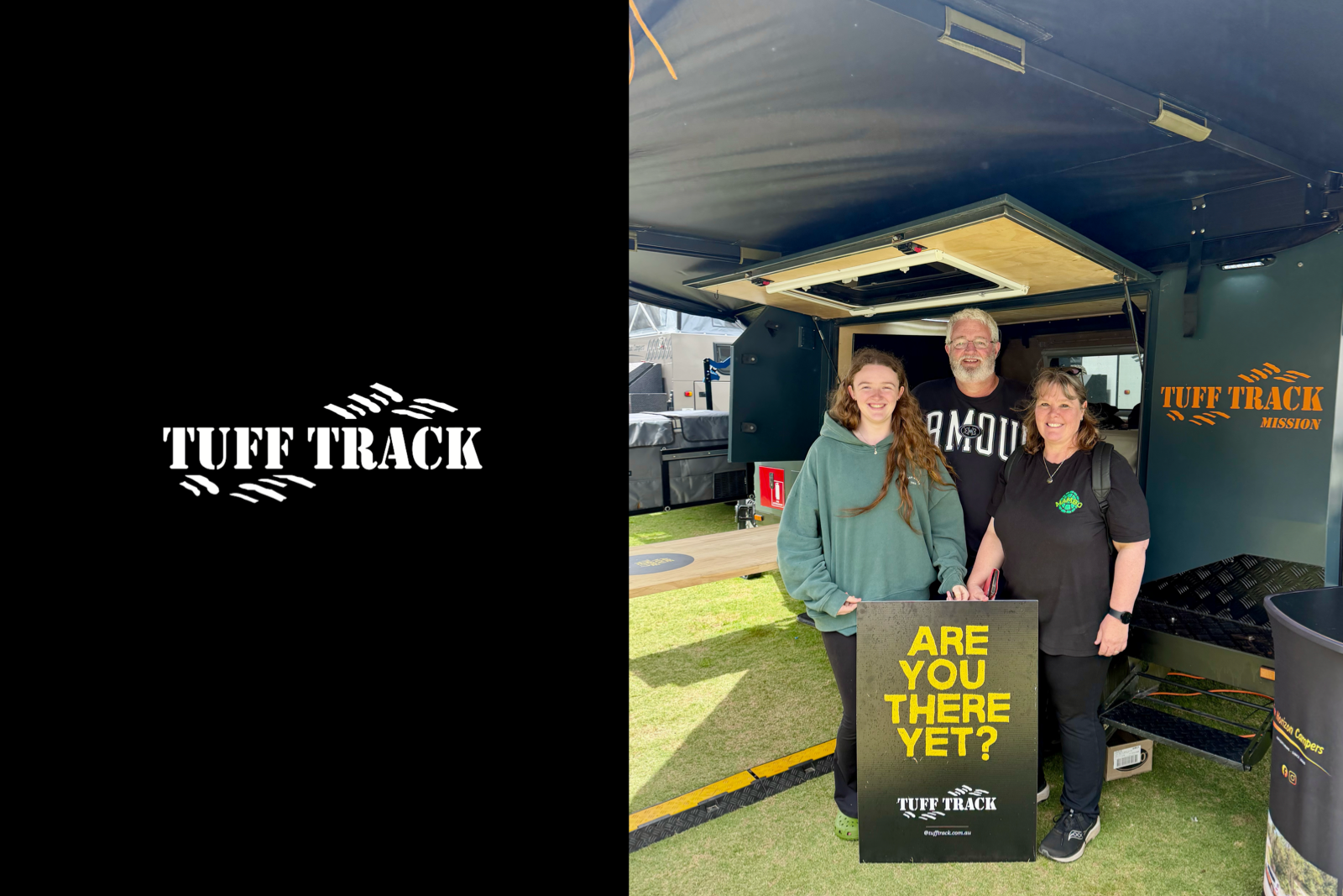 Three people standing in front of a TUFF TRACK Mission trailer at an outdoor event, with a sign that reads "ARE YOU THERE YET?" in yellow letters. They are smiling at the camera.