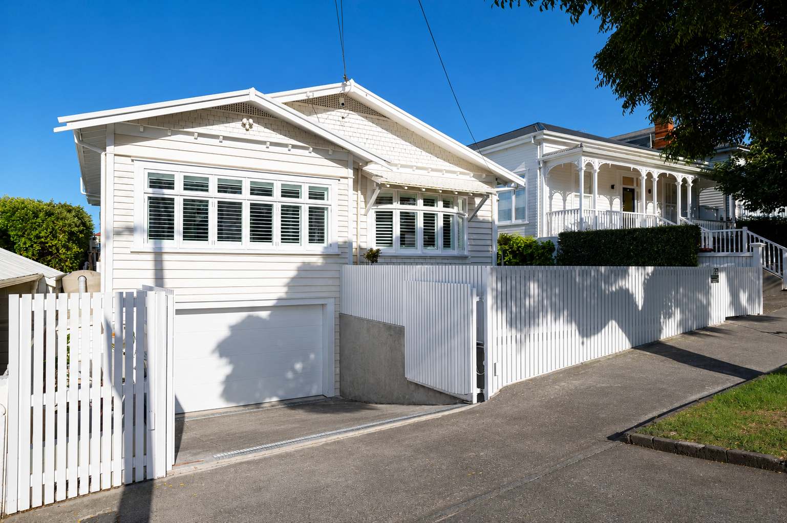 Contemporary white front boundary fence and pedestrian gate complementing a renovated heritage home in Auckland, New Zealand.