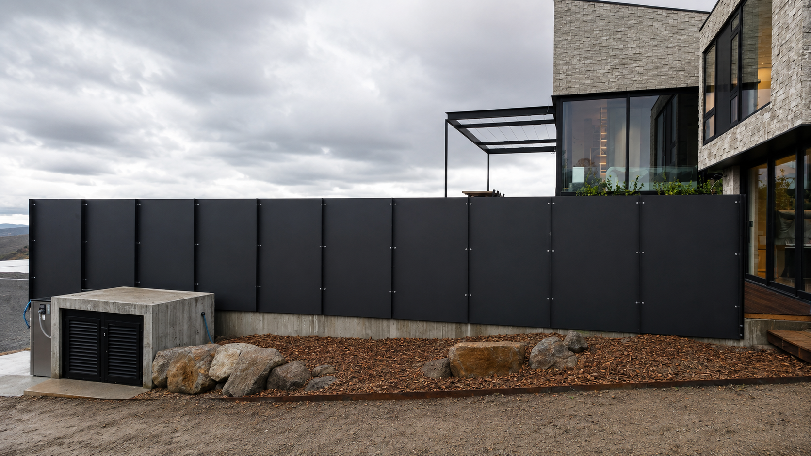 Custom powder-coated steel privacy fencing installed alongside a contemporary home in Te Arai, Auckland, featuring modern steel panels designed for privacy, durability, and a clean architectural finish.