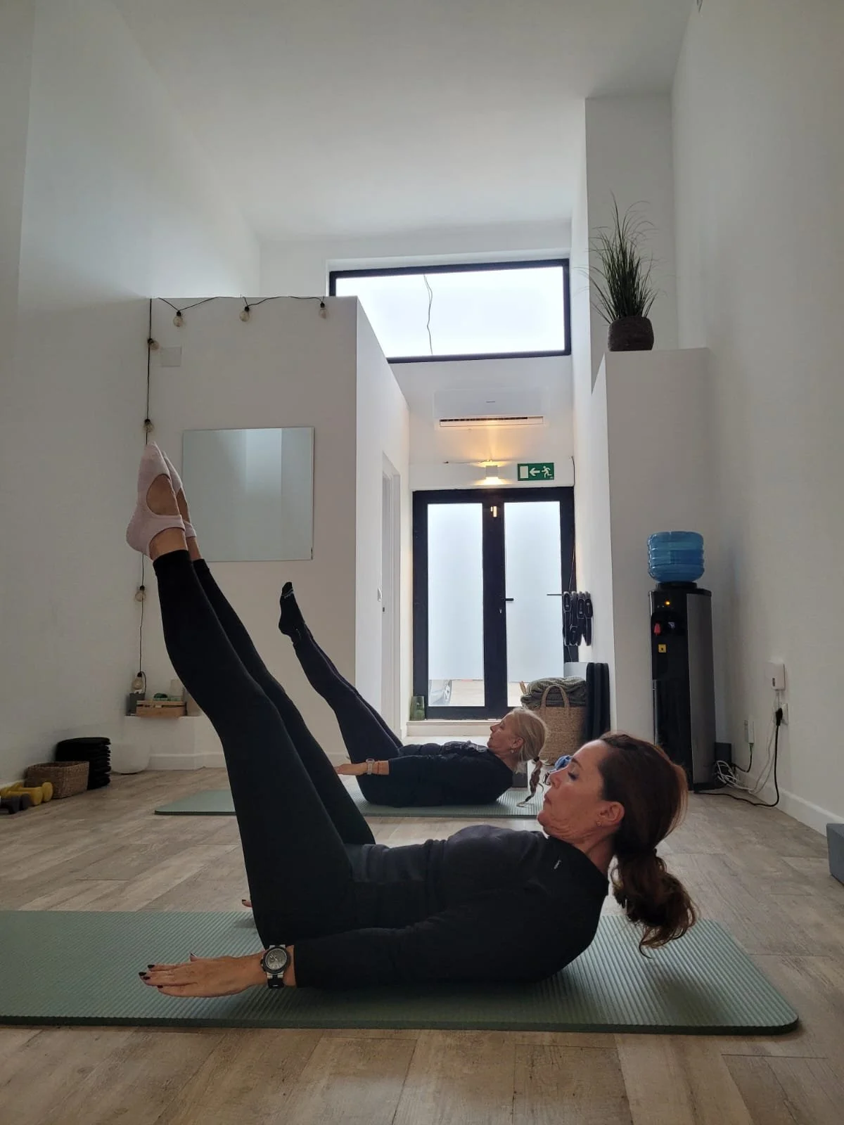 Dos alumnas de Alma Studio Palmanova en clase de pilates suelo.