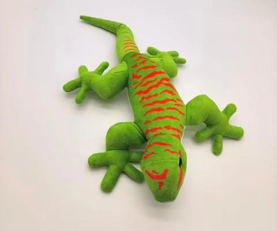 Peluche en forme de lézard vert avec des rayures rouges, vue de dessus sur fond blanc