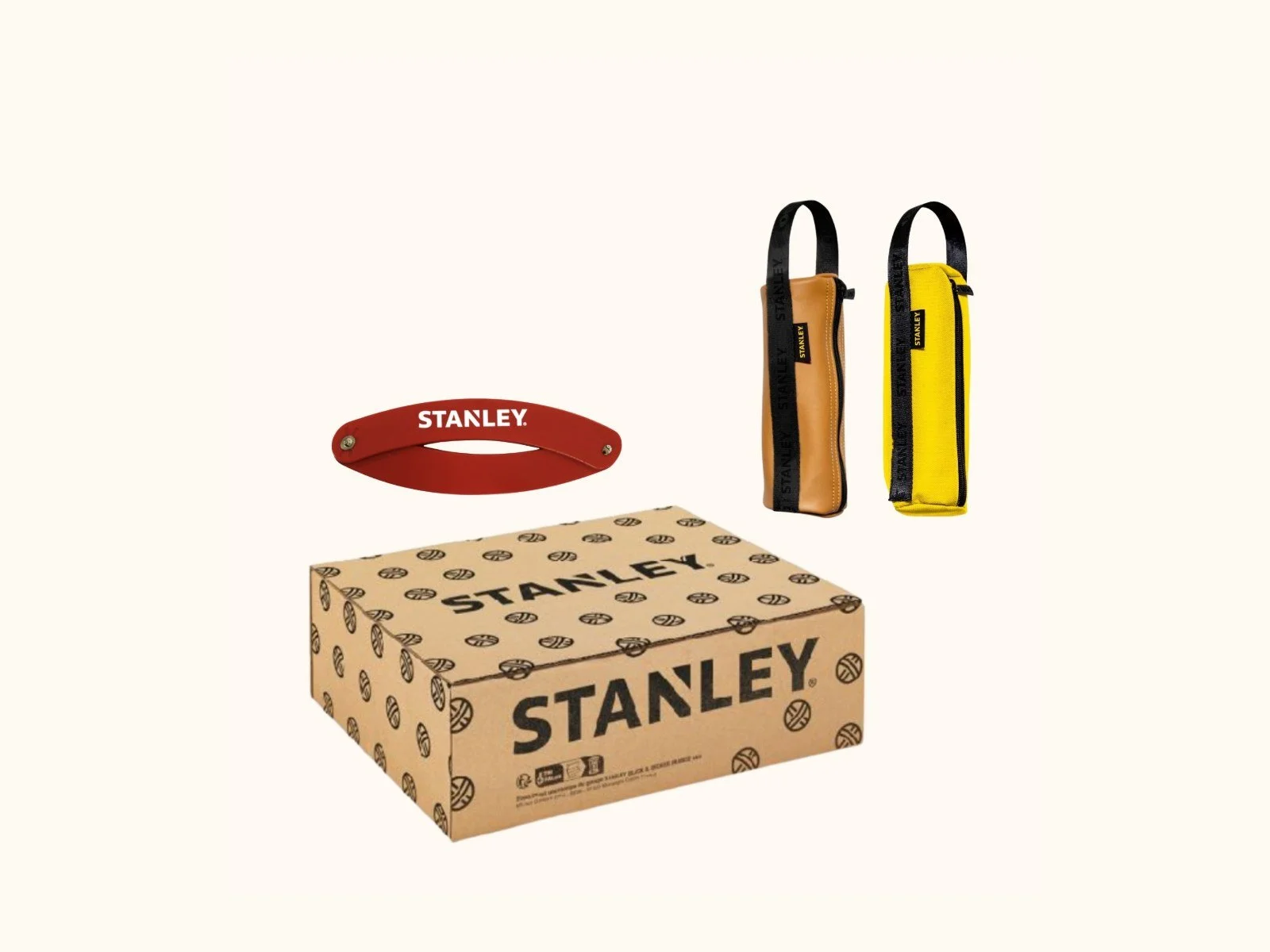 Coffret Stanley avec boîte en carton, deux étuis porte-outils jaunes et marron, et poignée rouge.