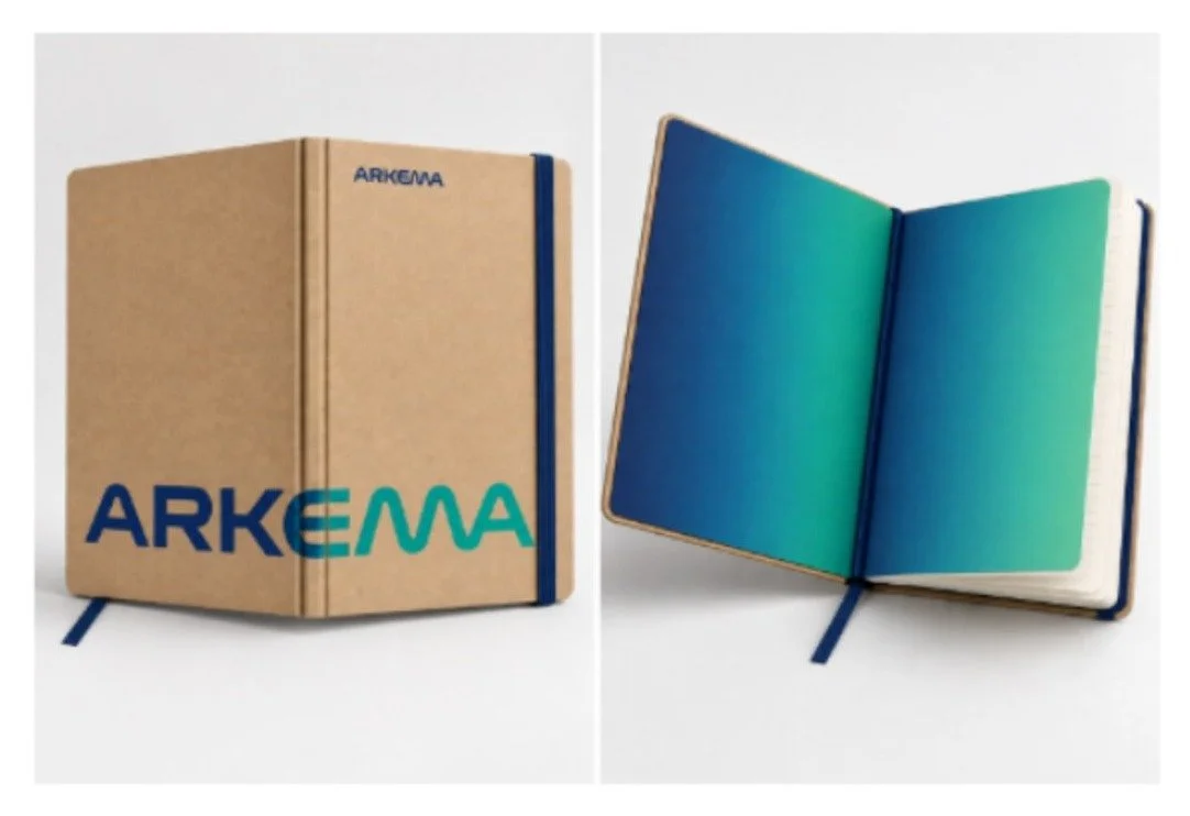 Carnet personnalisé Arkema à couverture kraft, présenté fermé et ouvert avec pages colorées bleu-vert et marque-page bleu.
