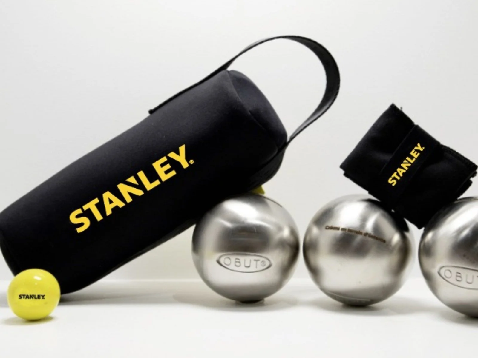 Boules de pétanque Obut en acier, cochonnet jaune et sacoche noire Stanley.