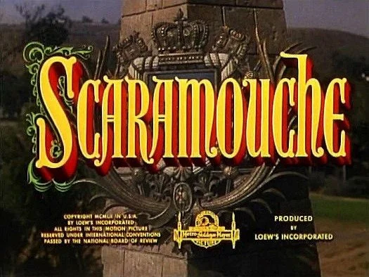 Title screen for the movie 'Schenmouche' with a decorative background and a key illustration, produced by Loew's Incorporated.