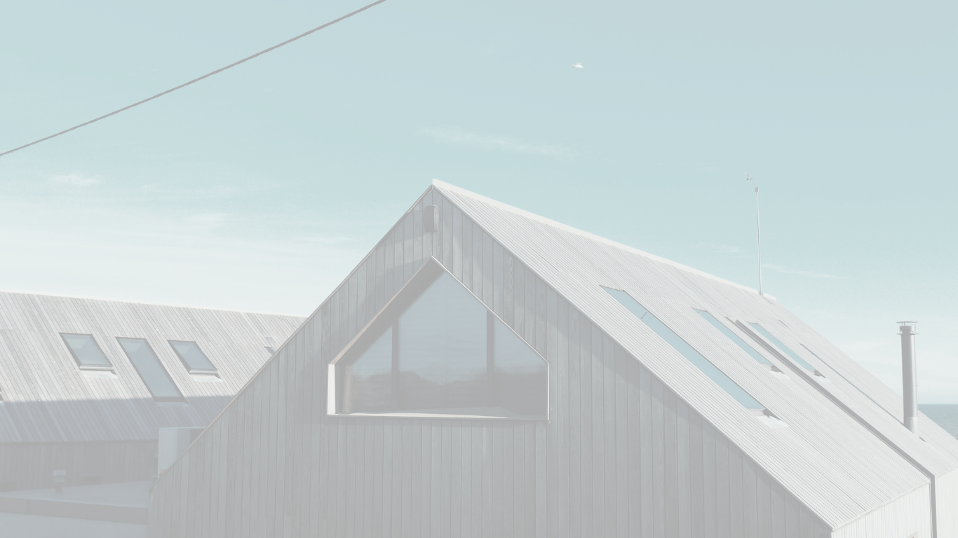 Modern house with a steep gabled roof and large window under a clear sky.