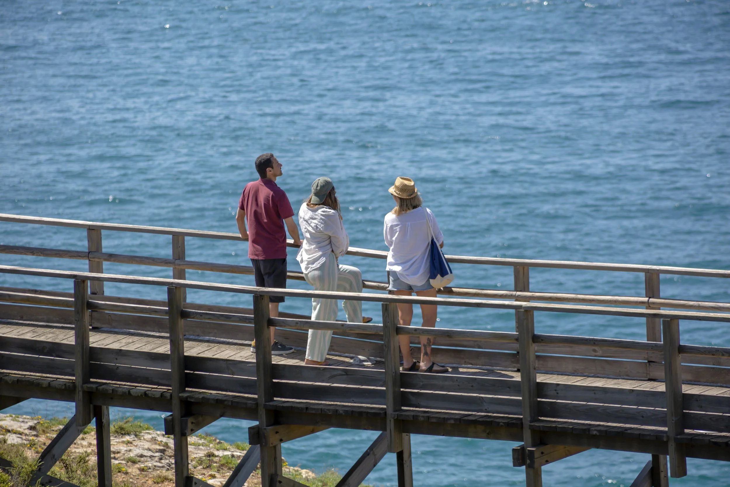 Three people hanging out at Carvoeiro boardwalk
