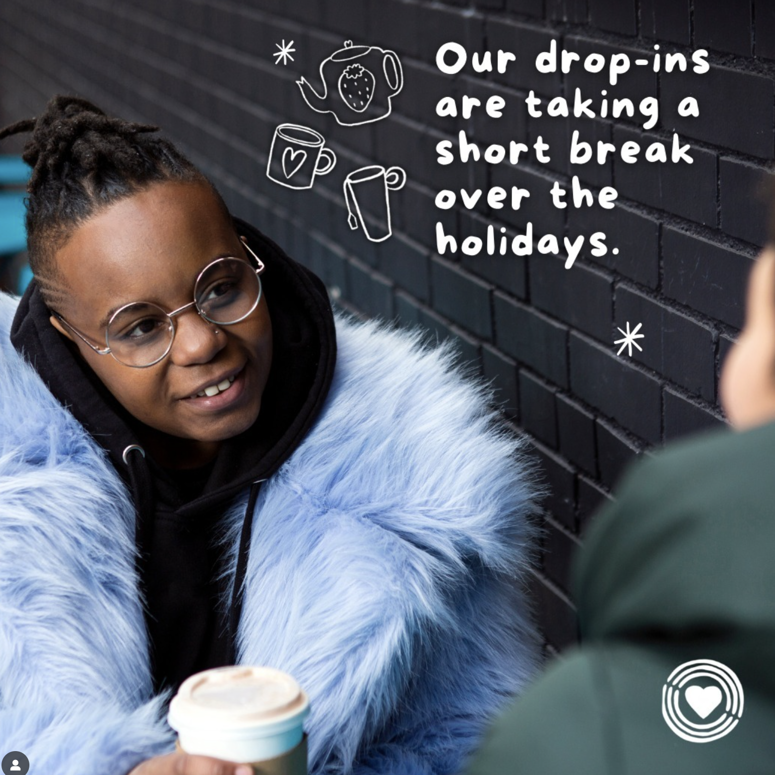 A person with glasses and a black hoodie, wearing a blue fur coat, smiling and holding a coffee cup, talking to someone outside the frame. Text on the image reads, 'Our drop-ins are taking a short break over the holidays,' with doodle illustrations o