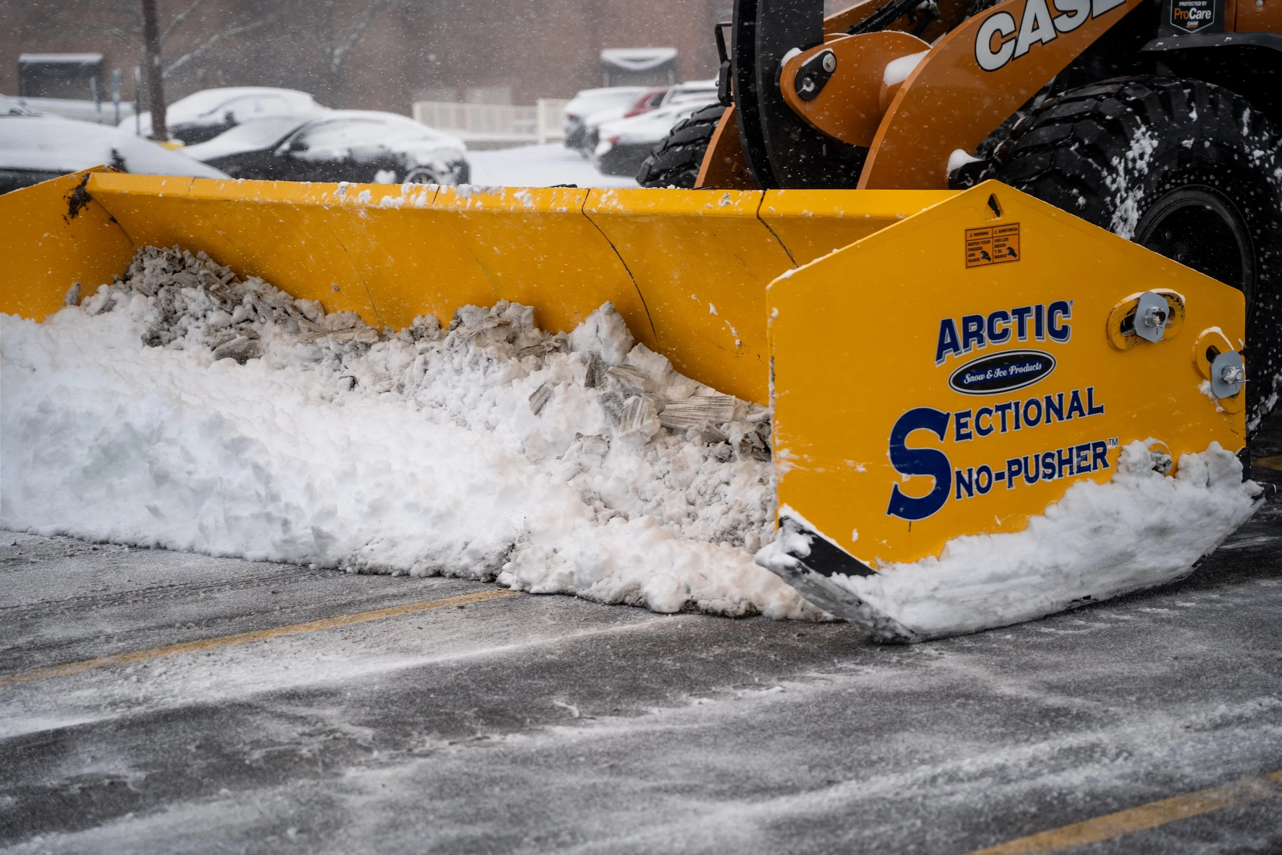 ARCTIC Sectional Sno-Pusher on a CASE front end loader