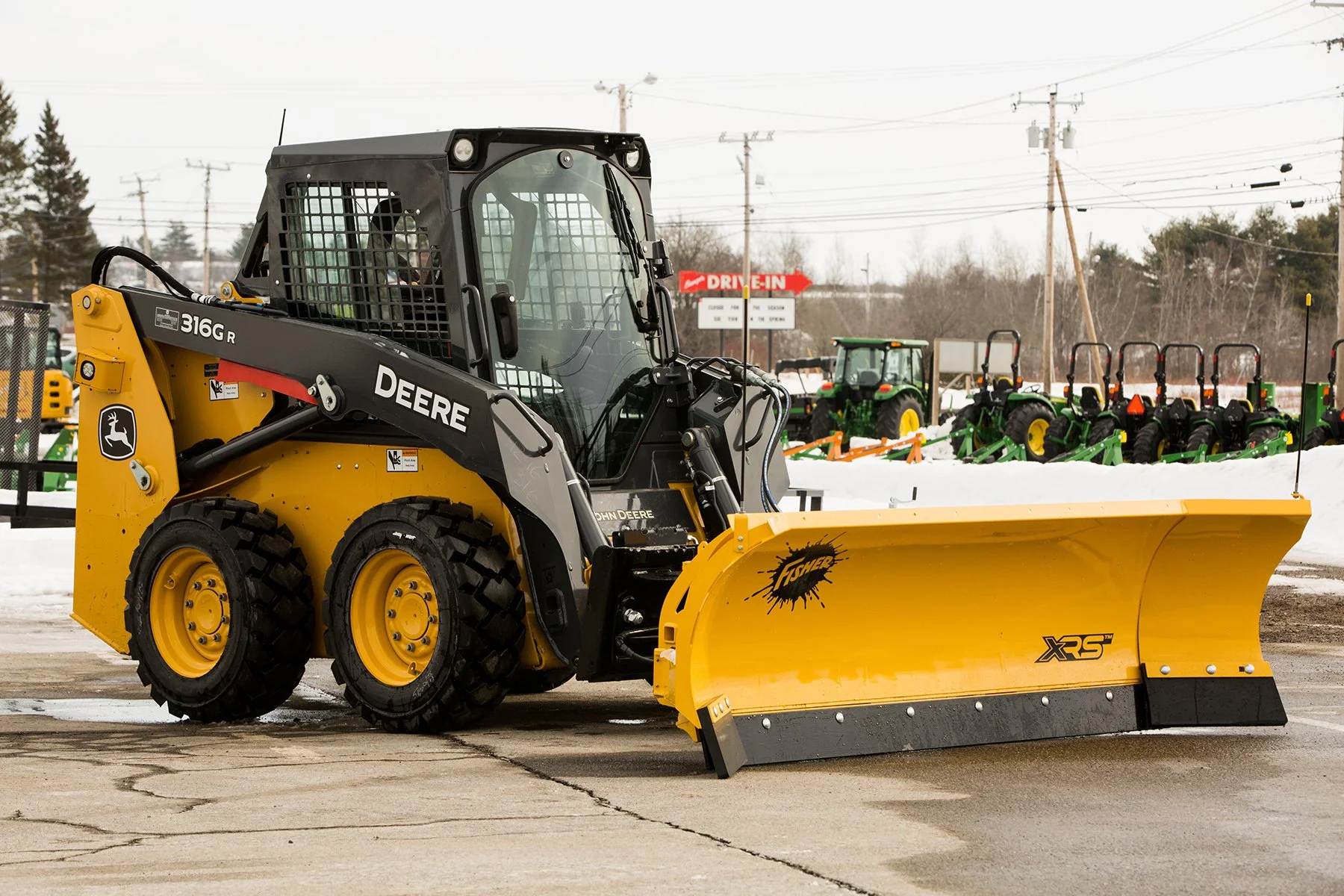 Hero Shot of a Fisher XRS snow plow with wings attached to a Deere Skid Steer