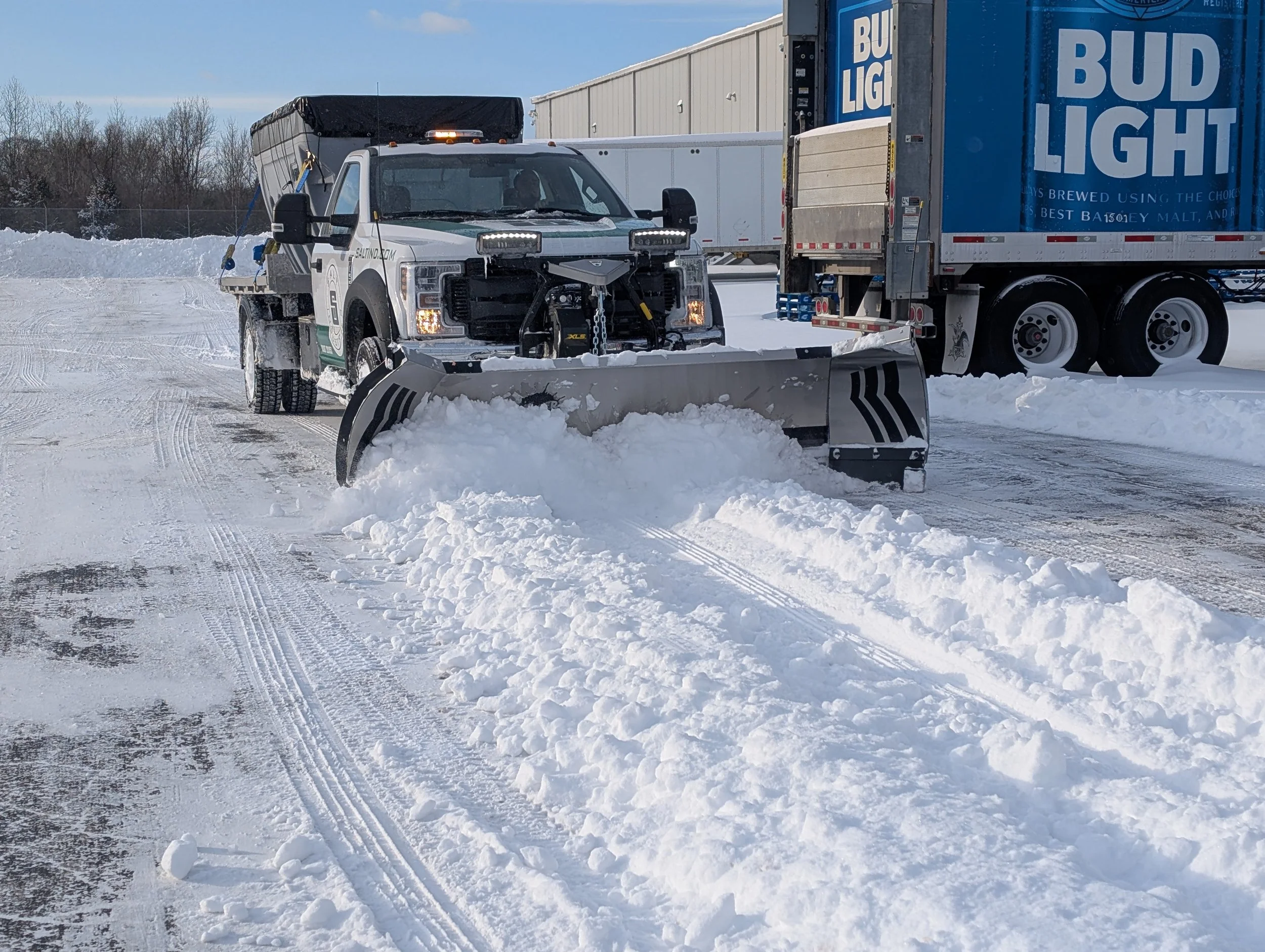 Action shot of a Fisher XLS snow plow mounted to a Ford F550. Pushing Snow