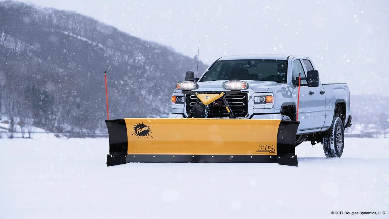 Hero Shot of a Fisher HD2 snow plow with wings and halogen lights attached to GMC 2500 Truck
