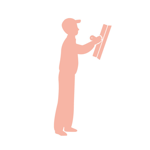 Silhouette of a person in a baseball cap looking at a sketch or drawing on a board or paper