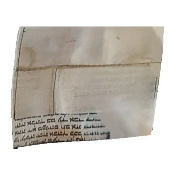 Close-up of a white tiled wall with black handwritten text at the bottom.
