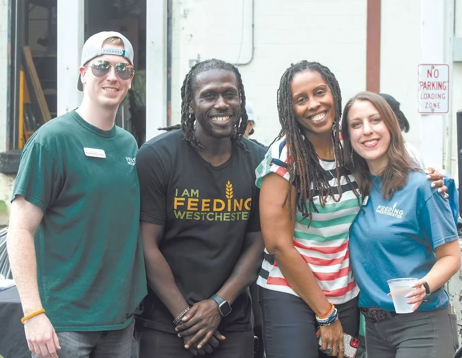Group of people at an annual Golden Scoop competition where representatives from local companies compete against each other to see which team can pack the most food.