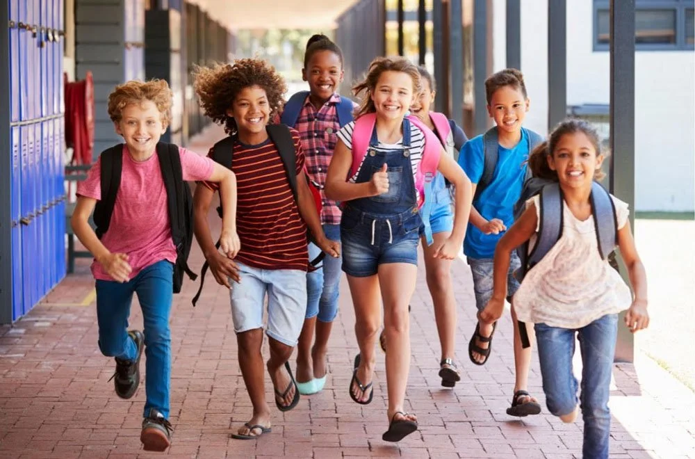 Kids running down the hallway at school.
