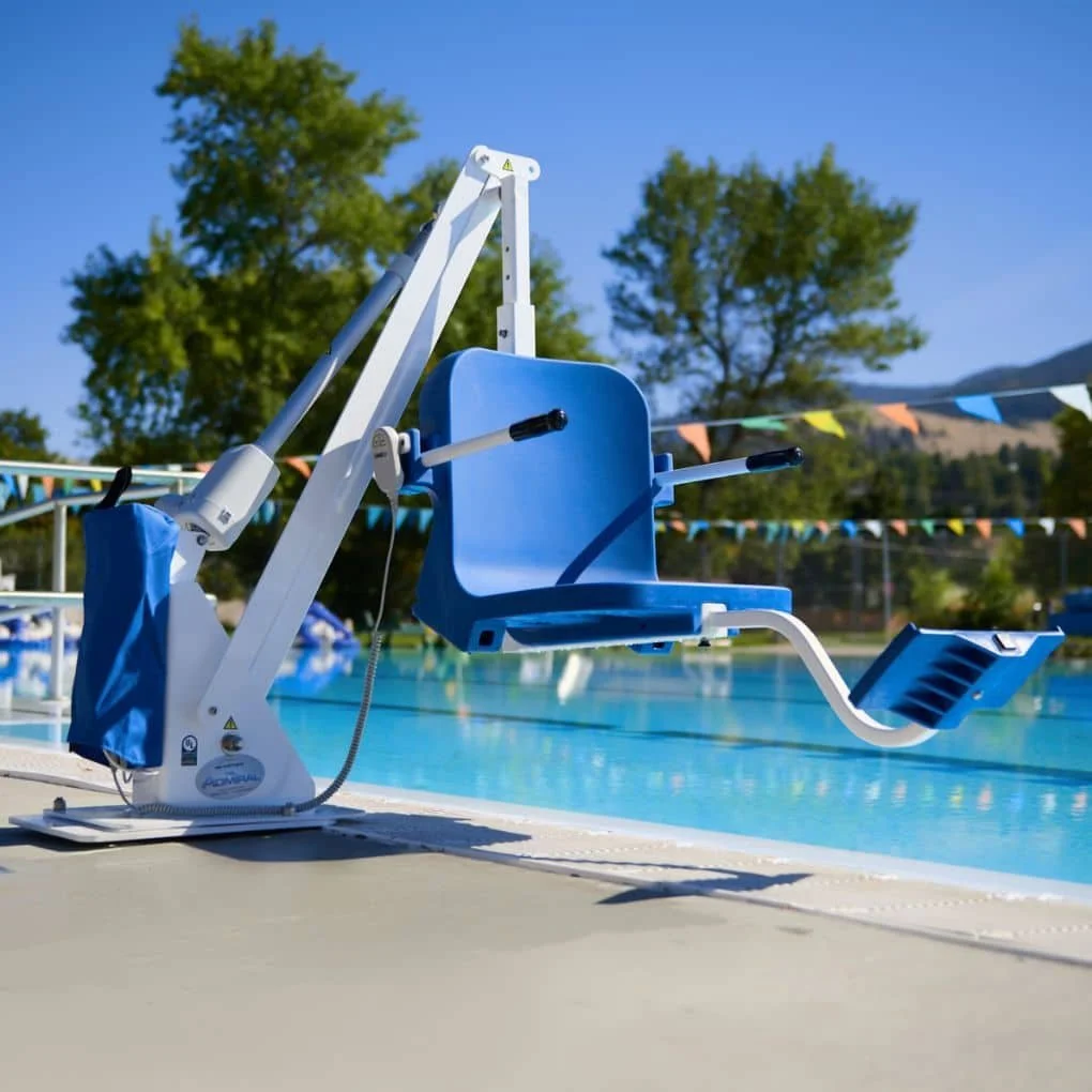 A aqua creek chair lift or spa pool lift chair positioned outdoors near a pool, with trees and hills in the background, in black and white.