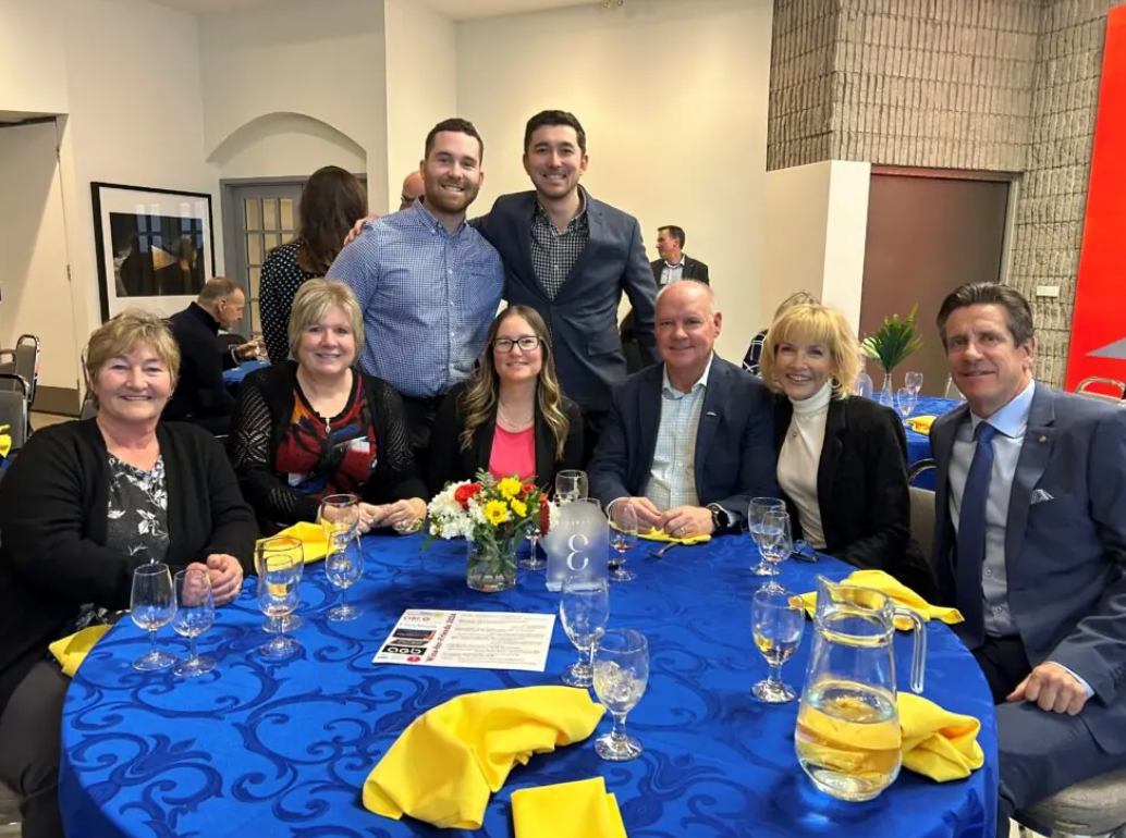 Members of Utter Morris team at a charity event smiling around a table
