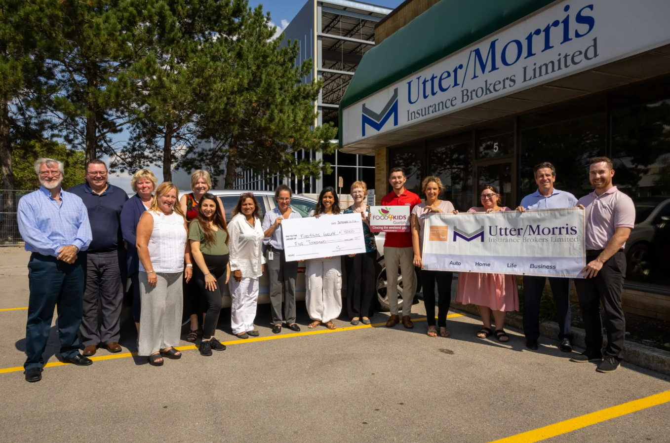 Utter Morris team standing with a donation cheque in front of their office in Burlington for the food bank