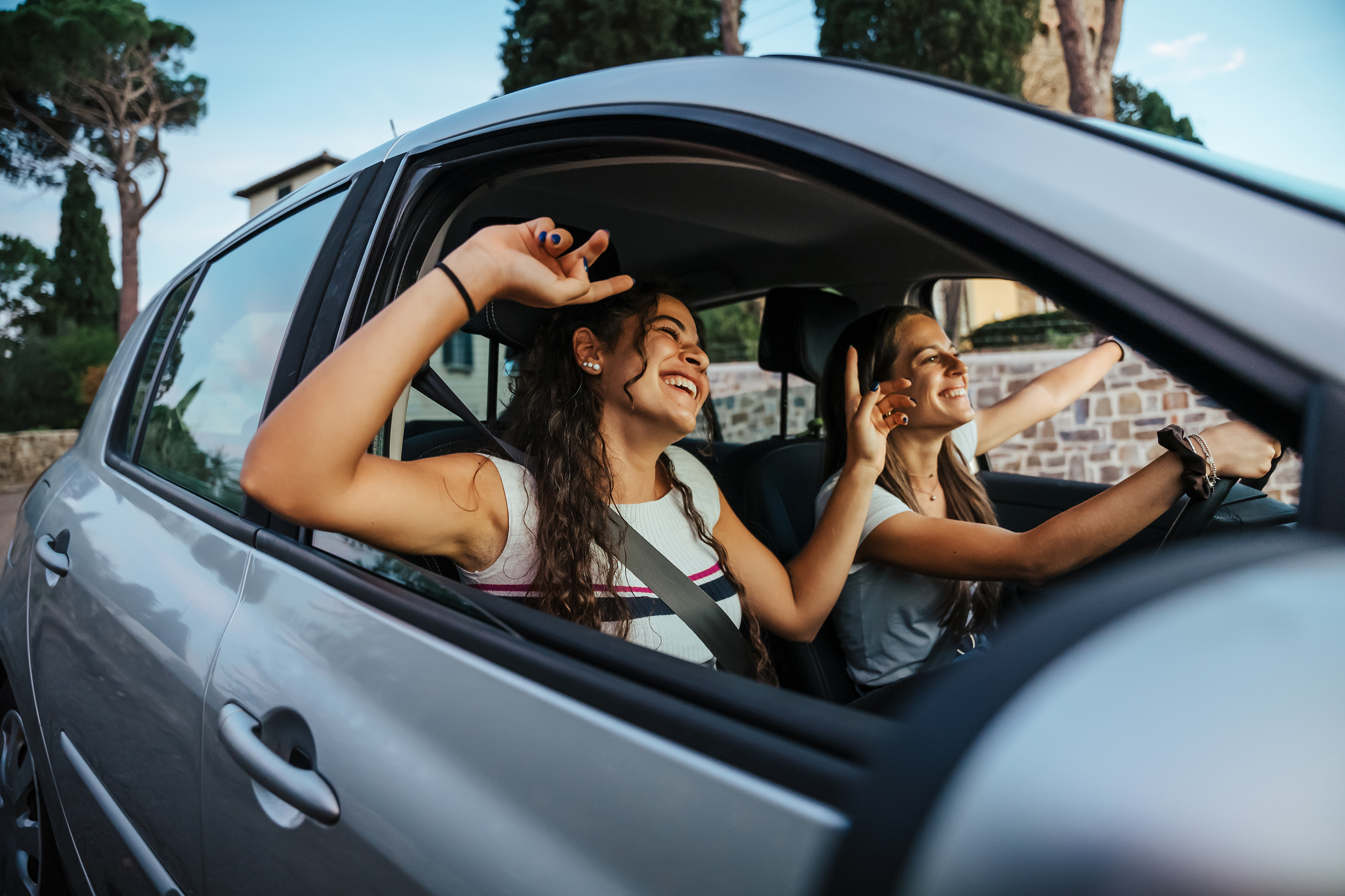 Two best friends having fun together singing and driving around