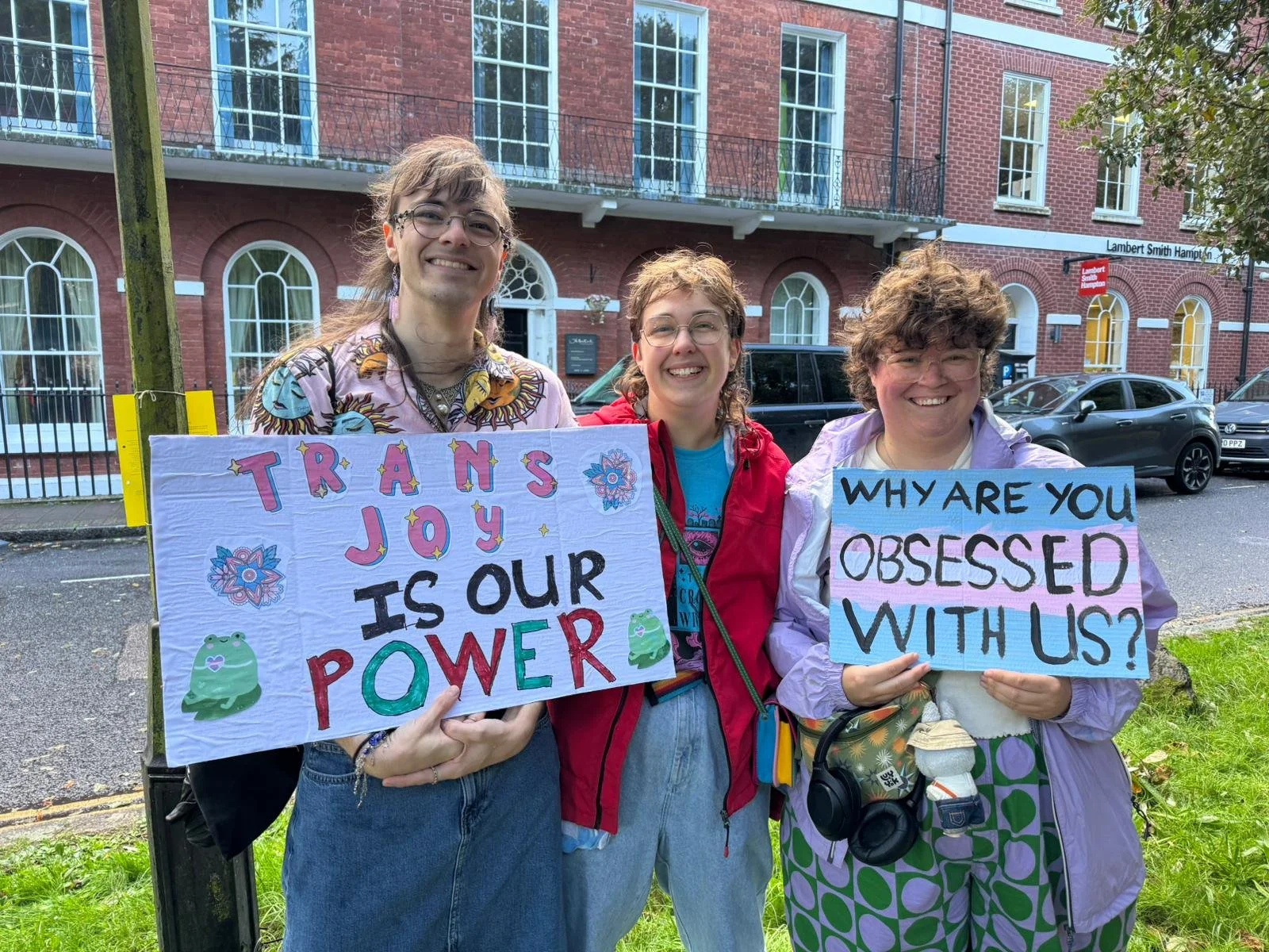Signs: "Trans Joy is our Power" and "Why are you obsessed with us?"
