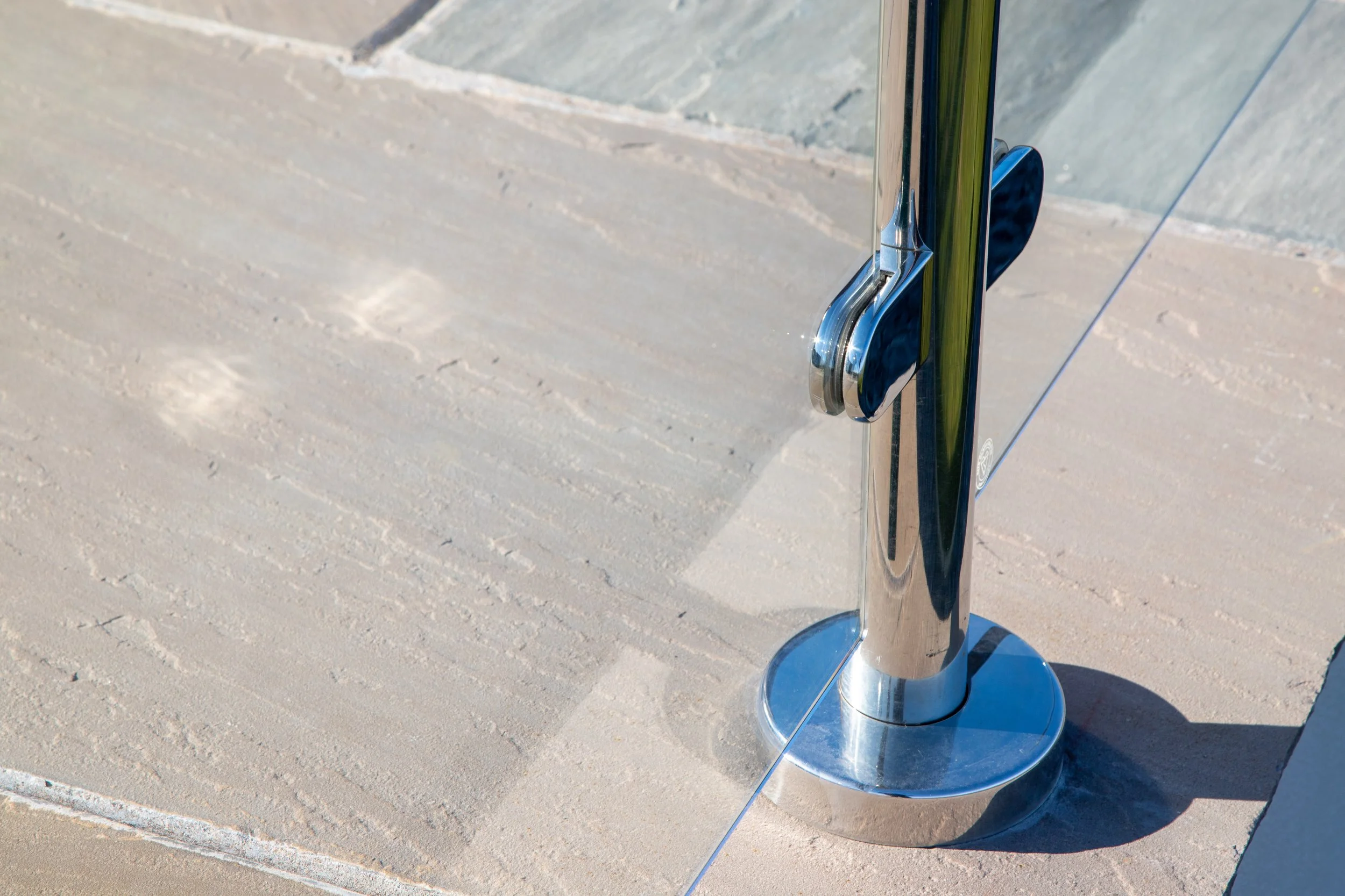 Close-up of a glass door with a metal handle on a concrete surface.